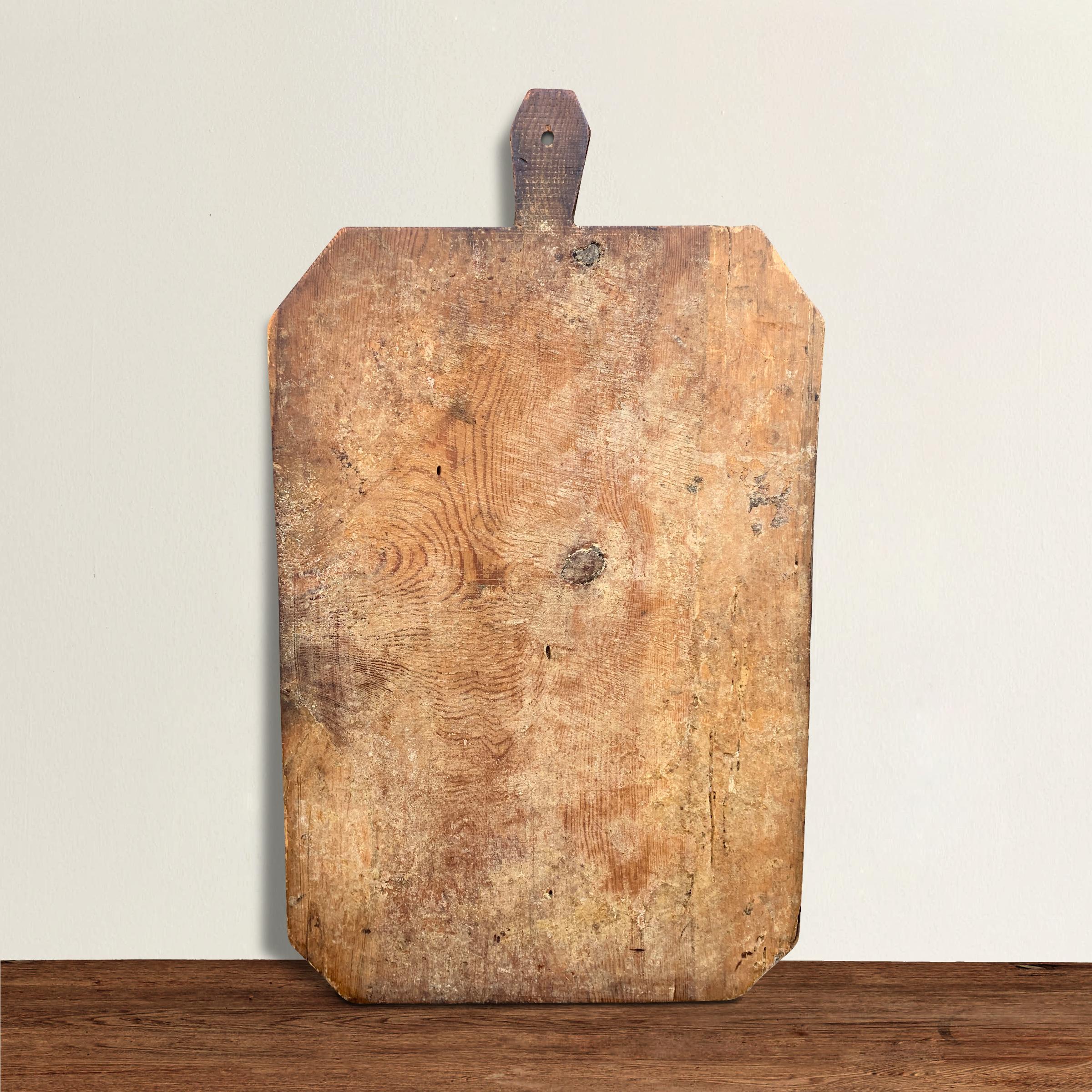 A wonderful early 20th century Italian pine breadboard with a fantastic patina from a hundred years of use. Perfect for serving cheese and charcuterie at your next fête, or the ever popular hot-chocolate board at your next winter gathering.