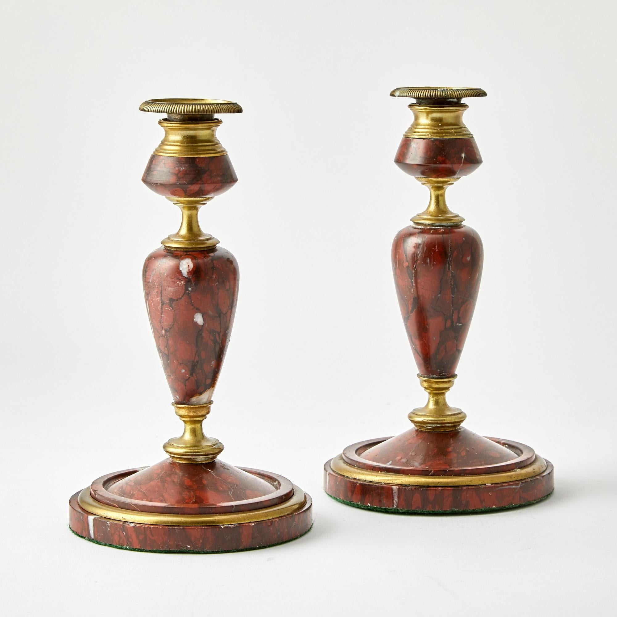 Questa elegante coppia di portacandele italiani dei primi del Novecento mette in mostra una miscela senza tempo di materiali lussuosi e di raffinata maestria. Ogni portacandela presenta un ricco inserto in marmo rosso, splendidamente incastonato in