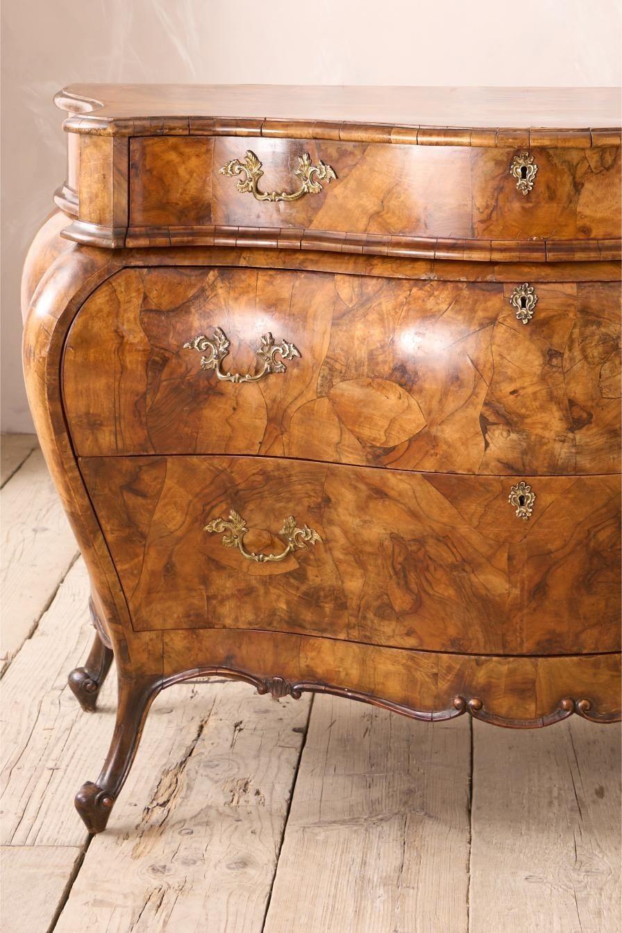 This is an absolutely stunning early 20th century burr walnut chest of drawers. The shape of the chest is gorgeous and extremely elegant. The figuring to the walnut is beautiful all over the body and also on the top. Each drawer runs smoothly and