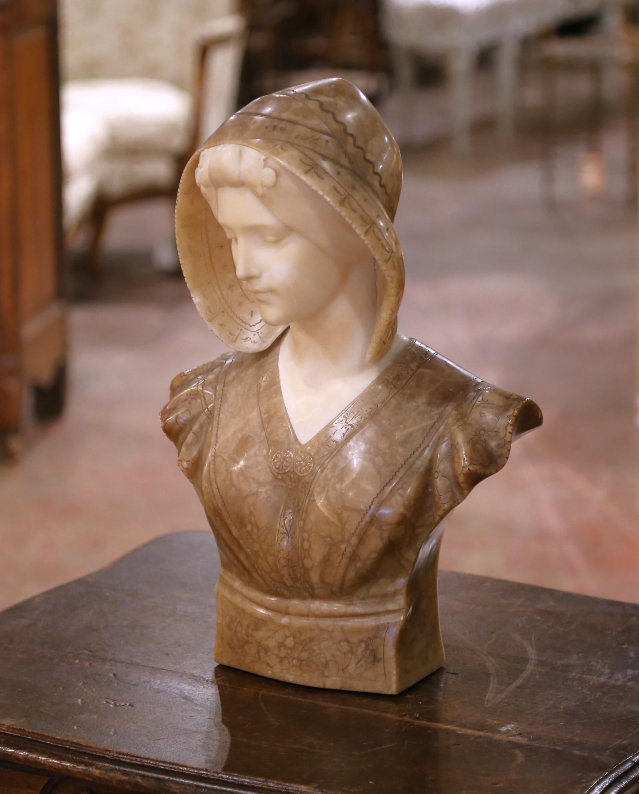 Sculpté en Italie vers 1900-1910, ce buste en marbre finement détaillé représente une jeune femme sereine en tenue de la Renaissance et est signé 
