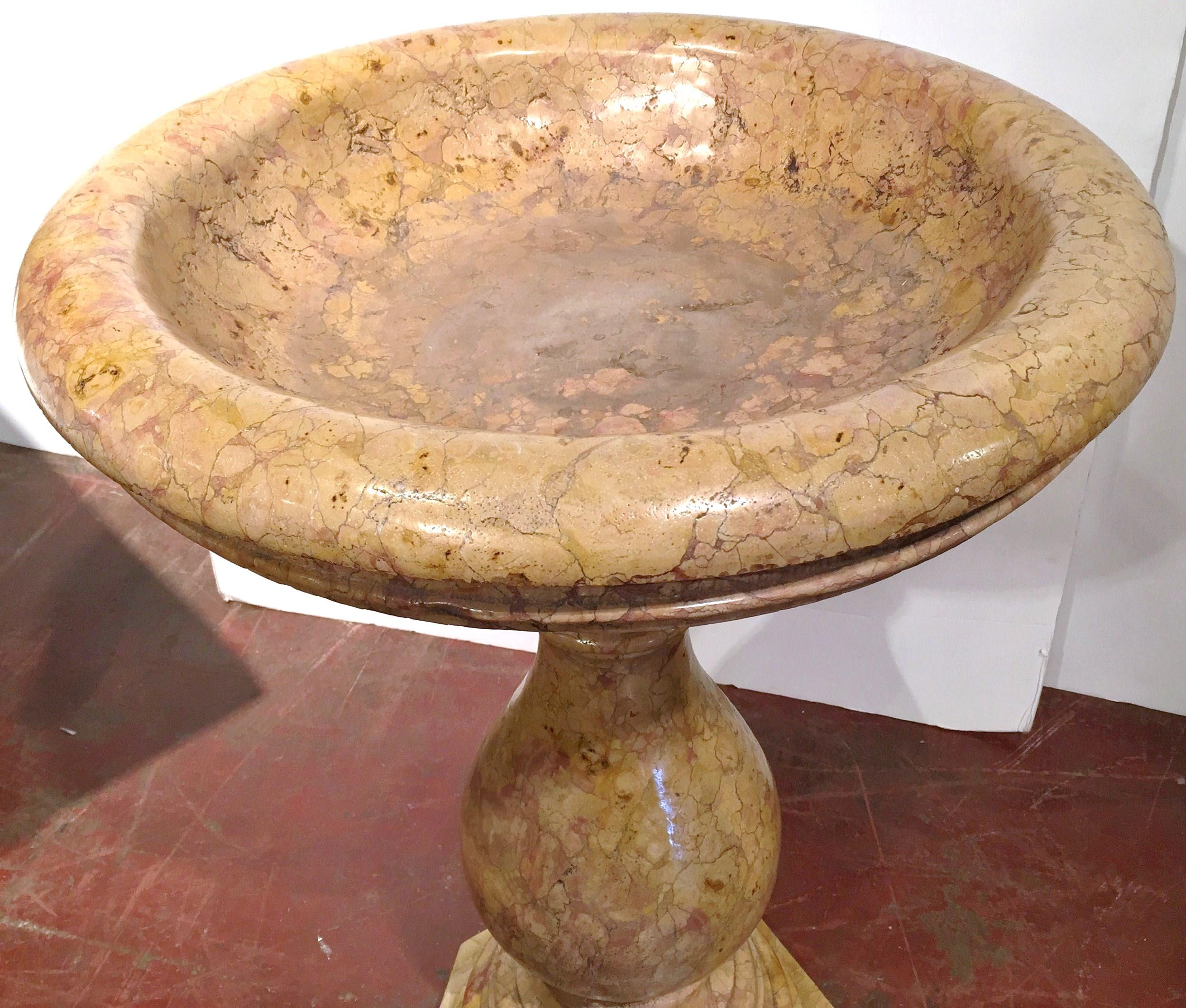 This large antique two-piece marble stand with bowl was crafted in Italy, circa 1920. The classical, Roman style jardinière sits on a carved pedestal base and is dressed with a wide swivel basin which could hold any kind of greenery. The elegant