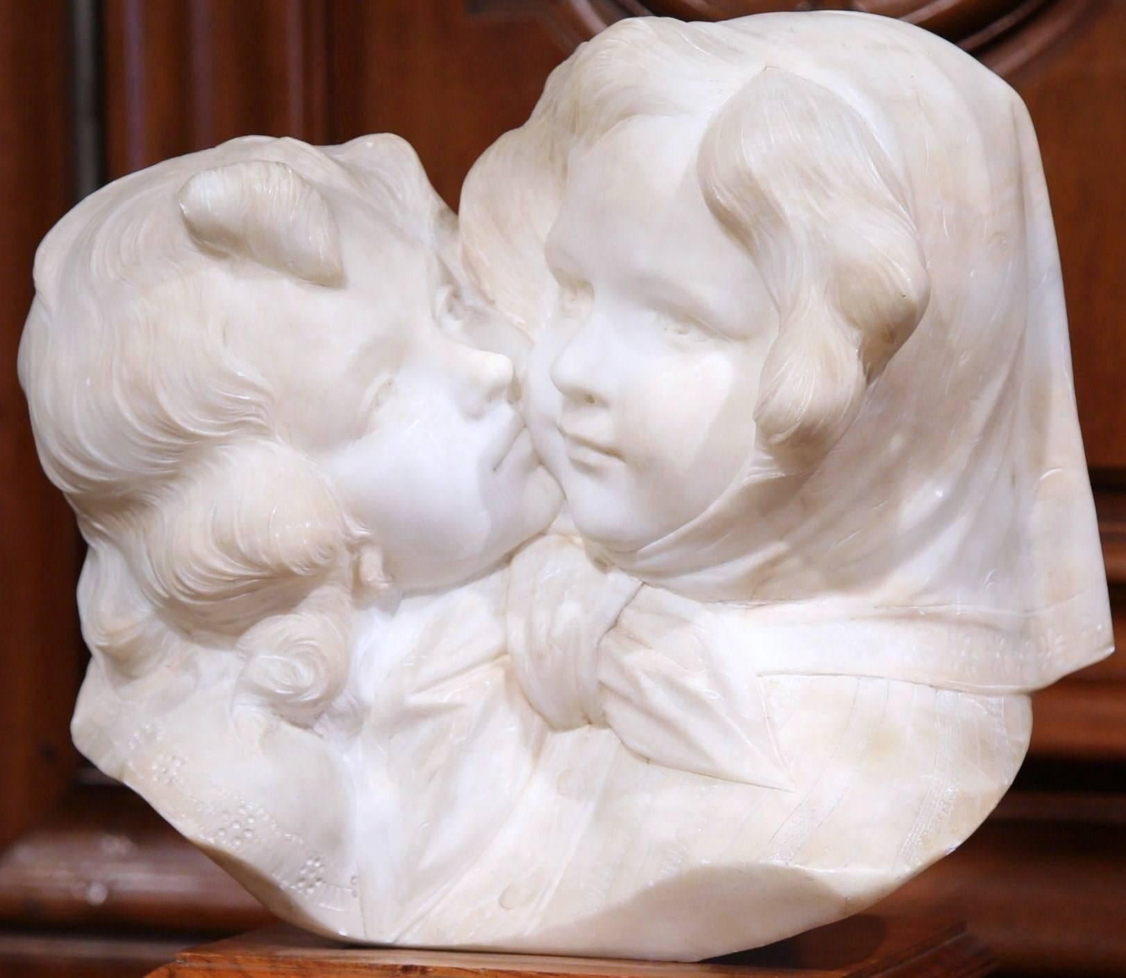Decorate a study or an office with this highly detailed antique white marble composition. Crafted in Italy, circa 1920, the carved sculpture features two young sisters beauties hugging each other. The bust sits on a separate, walnut stand for a