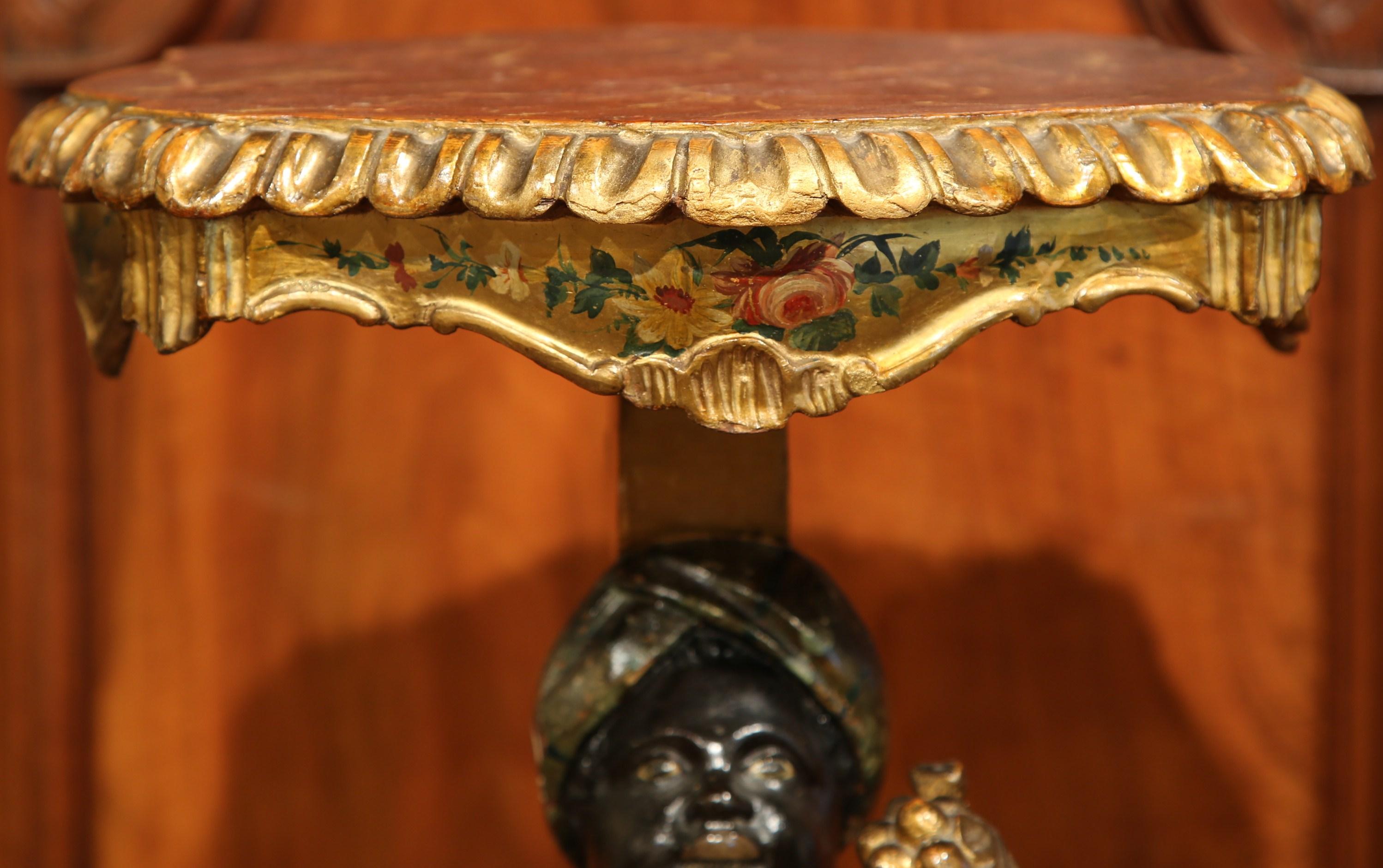 This intricate, antique hand-painted pedestal table was made in Italy, circa 1920. The colorful side table with carved and red painted marble top surface, sits on a three-leg foliage carved base decorated with painted flowers and luxurious gold leaf