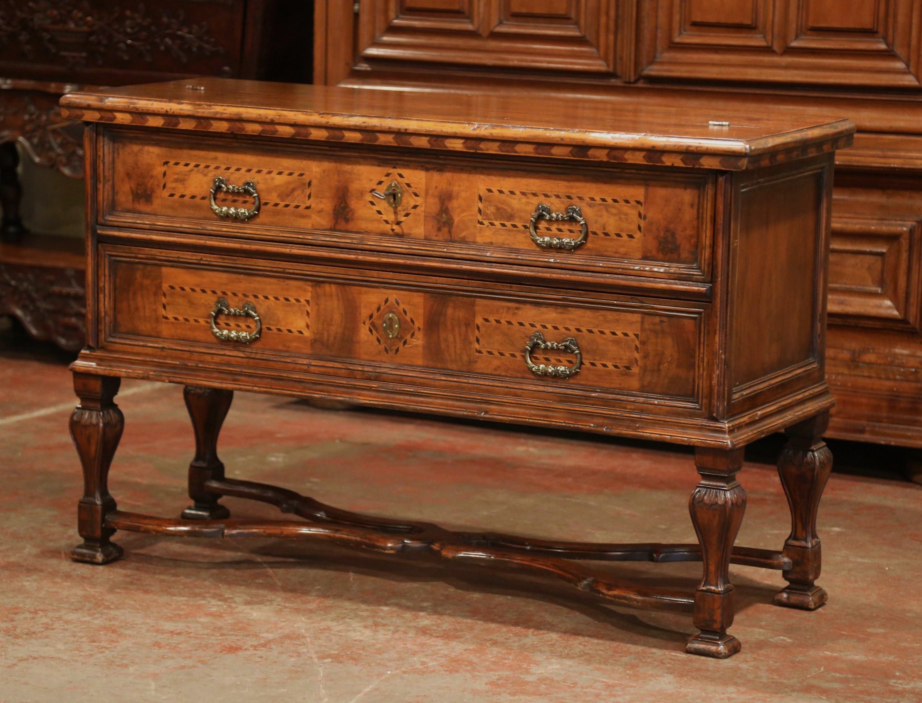 This elegant, multi-function fruitwood chest was created in Italy, circa 1930. The complex walnut cabinet sits on four carved legs embellished over a decorative bottom stretcher; the commode features what appears to be two drawers with marquetry