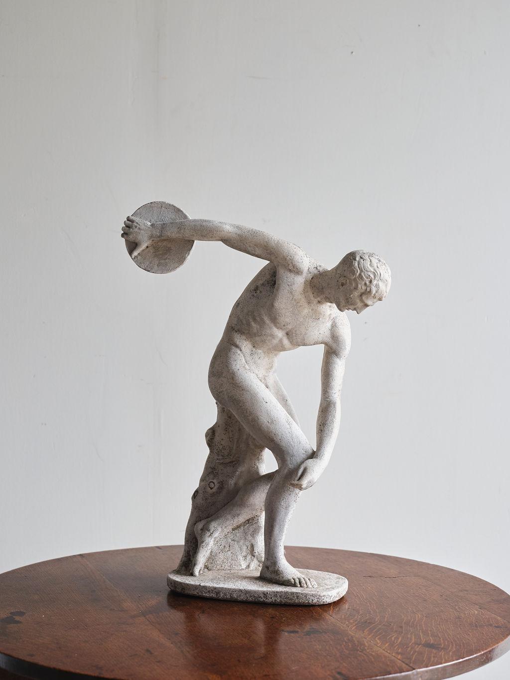 This early 20th century Italian classical composite figure of Discobulus would be a wonderful statement piece in your home of office. It is heavy and was handcrafted out of stone in 1920. This piece is in great condition, and there are no visible