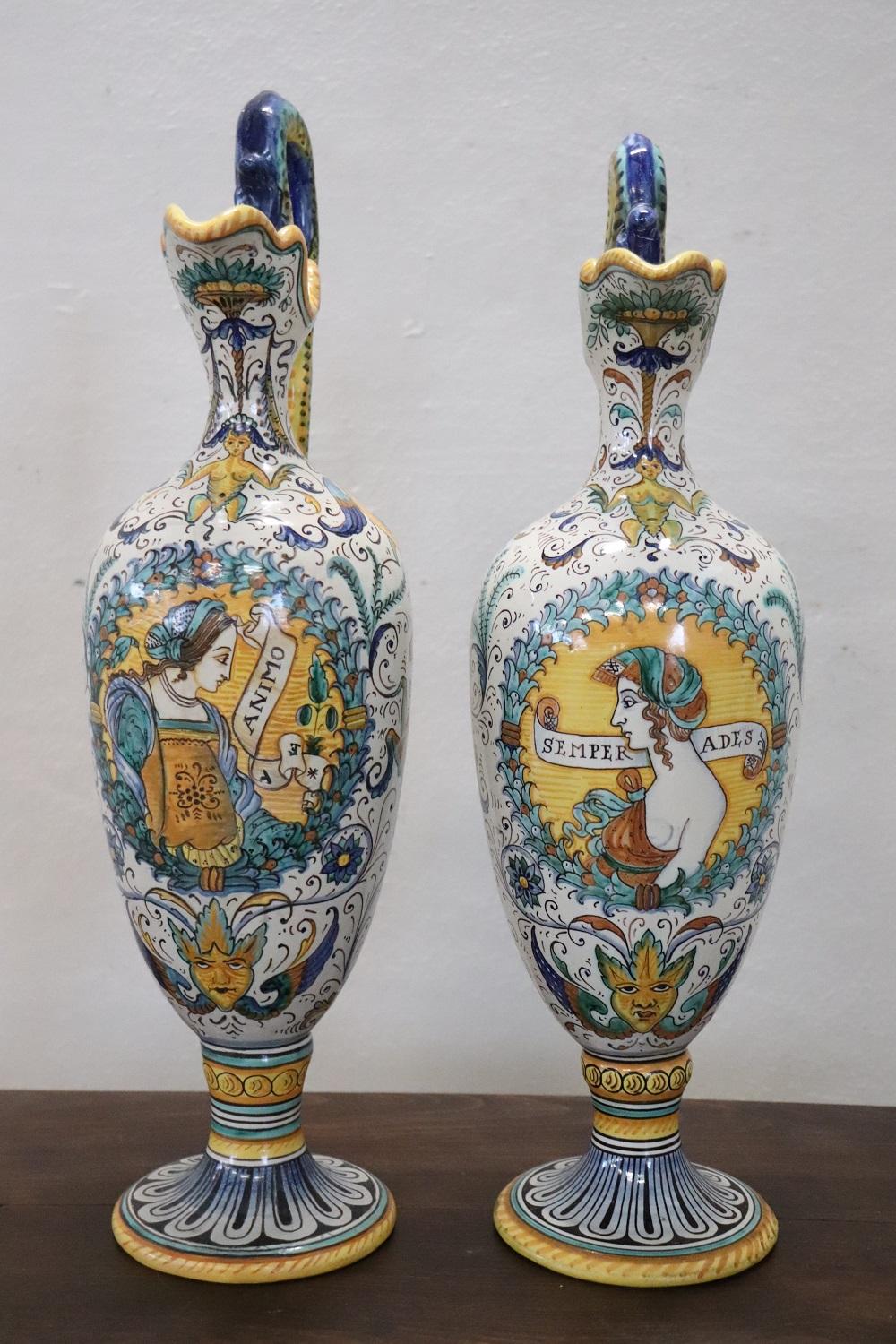 Early 20th century elegant pair of Italian-made Deruta amphorae, branded at the base. Characterized by a refined hand-painted decoration with Renaissance-inspired motifs. In perfect condition, the height is not exactly the same.