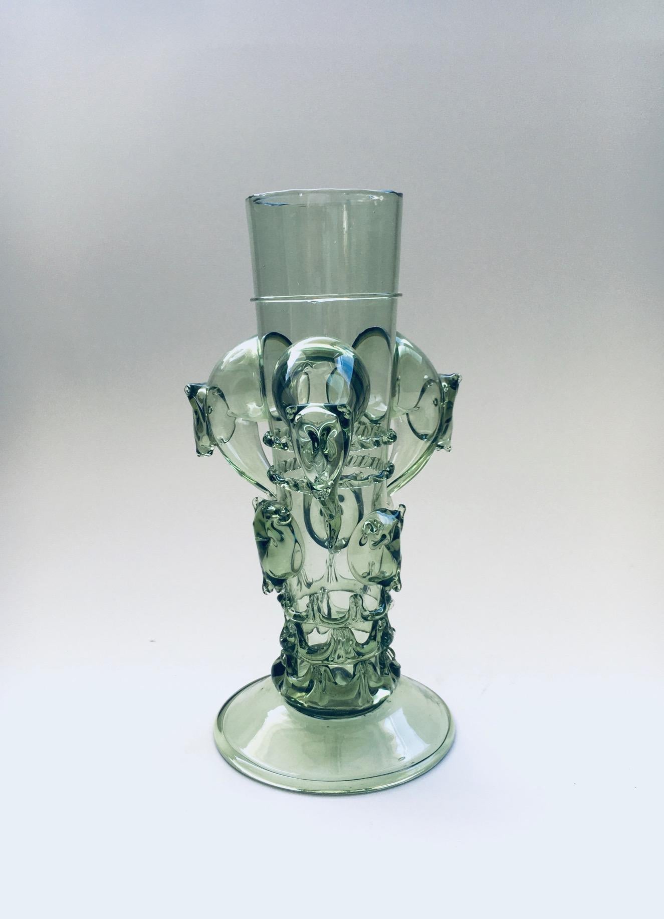 Vase en verre d'art original du début du 20e siècle, de conception italienne, en verre vert pâle. Fabriqué en Italie, dans la région de Murano, au début du XXe siècle. Magnifique vase en verre d'art soufflé à la main, vert pâle, entouré de figures