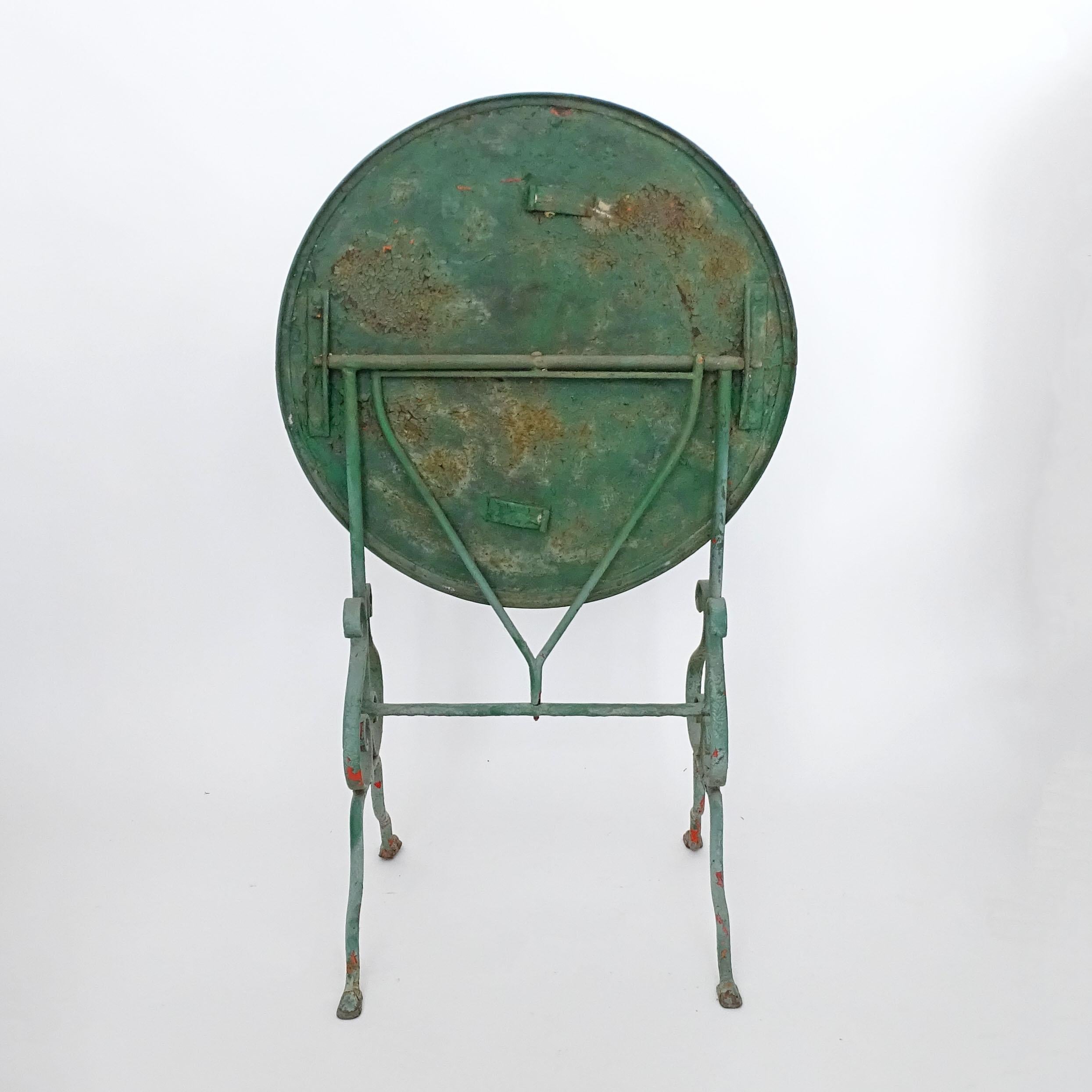 Italienischer Gartentisch aus dem frühen 20. Jahrhundert mit grüner Farbe auf alter roter Farbe, klappbar.
Ein faszinierender und ungewöhnlicher verstellbarer Drehmechanismus für den Deckel.