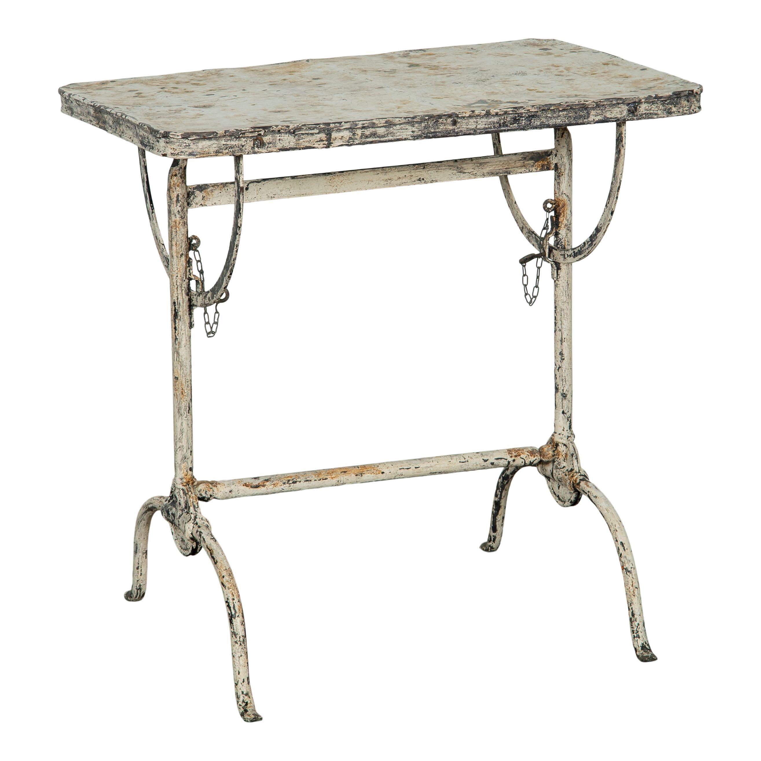 Table de bistro ou d'appoint en métal vintage italien avec un plateau pliant. Cette table en métal a été peinte en blanc et présente aujourd'hui la belle patine de la peinture écaillée et du métal apparent. Le plateau est fin et plat et deux