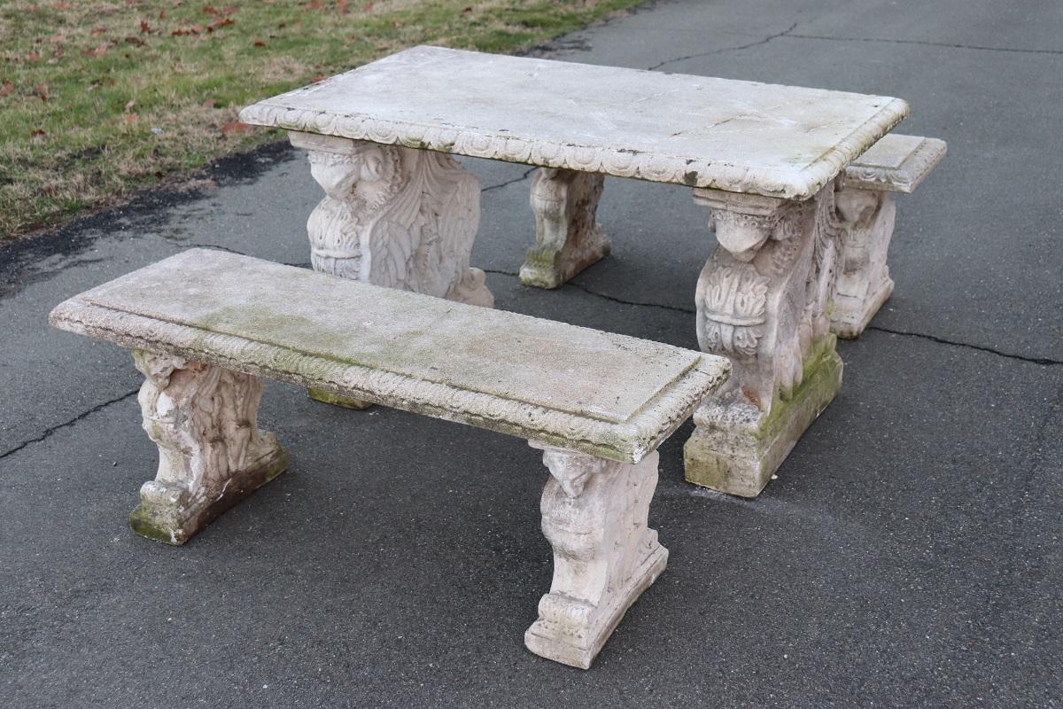 Beautiful refined garden set in neoclassical style, circa 1920s main material stone mixed with gravel and cement. Beautiful table with two benchs. Gorgeous carved decoration with large ram heads supporting the table top and the seats of the stools.