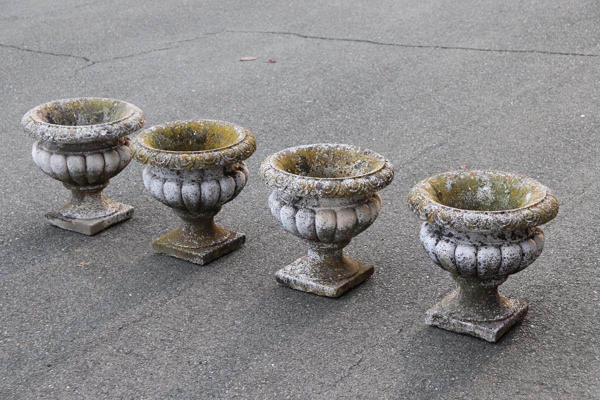 Beautiful and refined garden set of four vases, circa 1920s main material stone mixed with gravel and cement. The vases shows signs of the passage of time, see photo details. This garden set is perfect for embellishing an important garden or balcony.