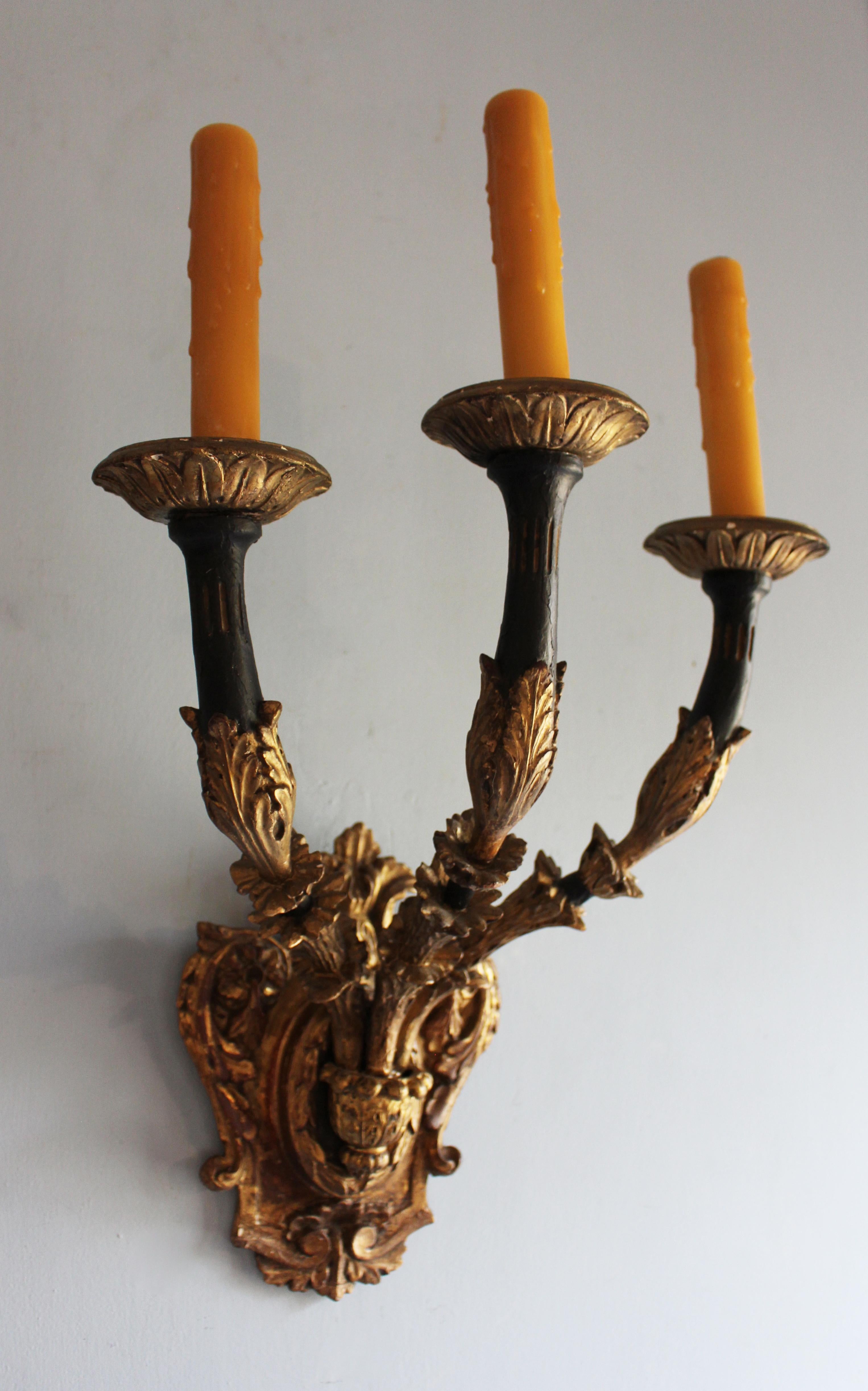 Early 20th century pair of 3-light wall sconces - gilt & ebonized carved wood. Italian. Shield wall plaques & Neoclassical acanthus motifs. Acquired by Albert Hadley for 1060 Fifth Ave, NYC. Shield: 8