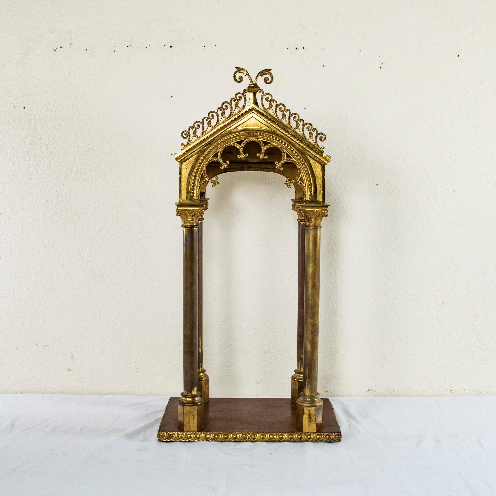 Standing at 39 inches in height, this large brass and wooden altar piece was originally used in an Italian church to display a statue. The roof of the altar piece is held up by four Corinthian columns that rest on a wooden base. The sides of the