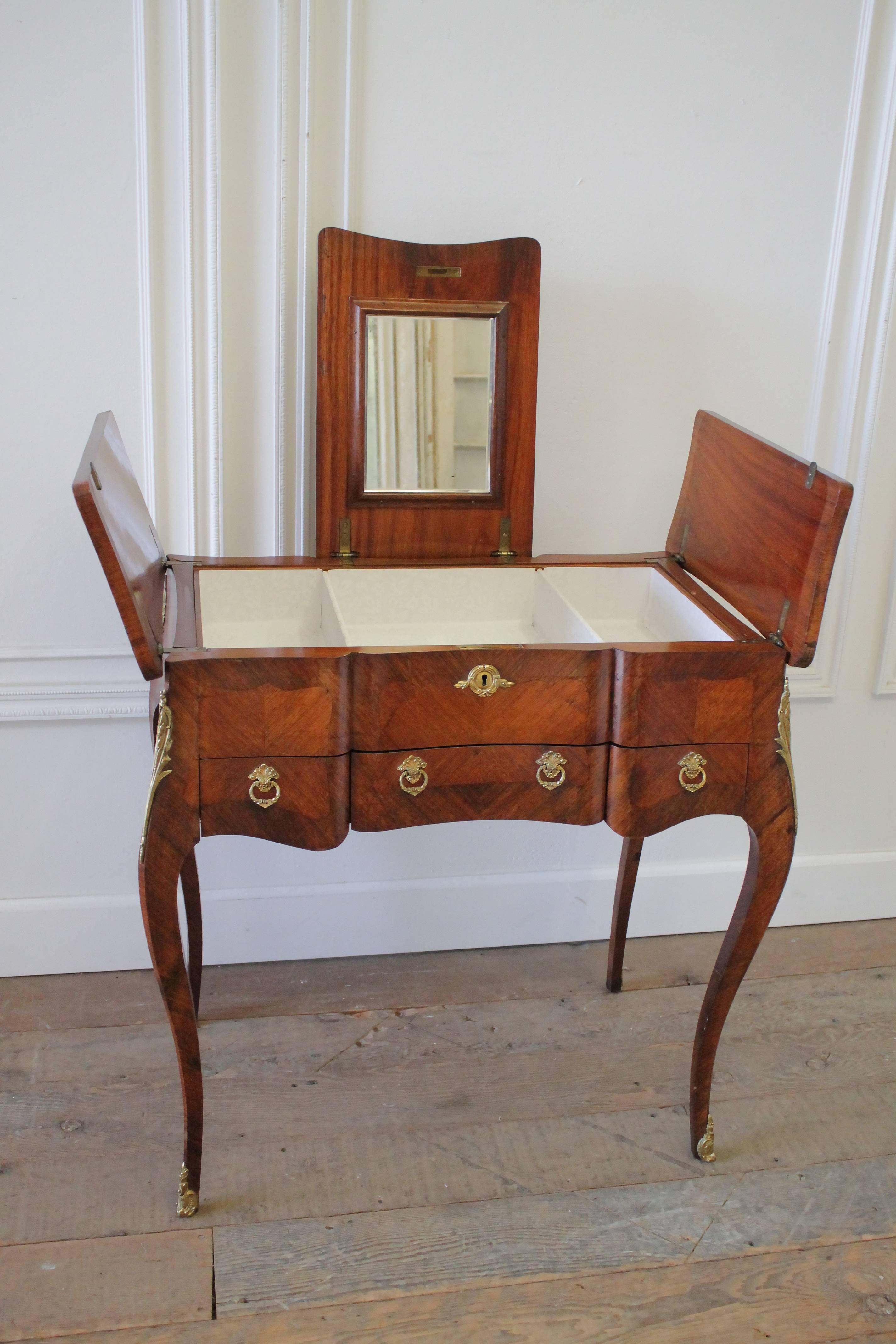 Early 20th century Italian inlaid vanity with original mirror and gilt bronze mounts and ring pulls. Drawers are finished with a dovetail, and has a white lining that can be removed easily. The vanity top centre opens by lifting straight up, then