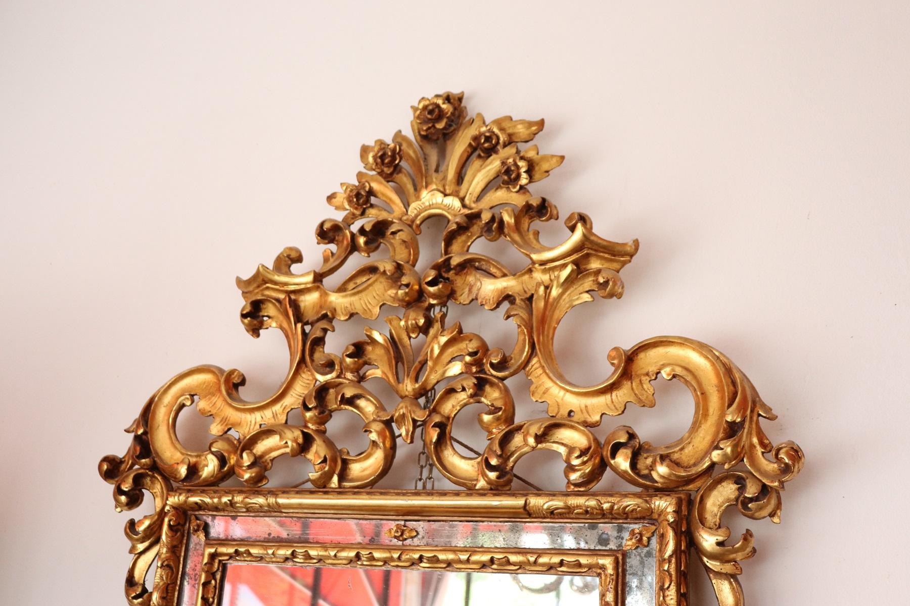 Luxury carved and gilded wood wall mirror with refined decoration. Very rich work in Louis XV style with curls and swirls. Perfect condition. This mirror is perfect for a refined and elegant home.
 