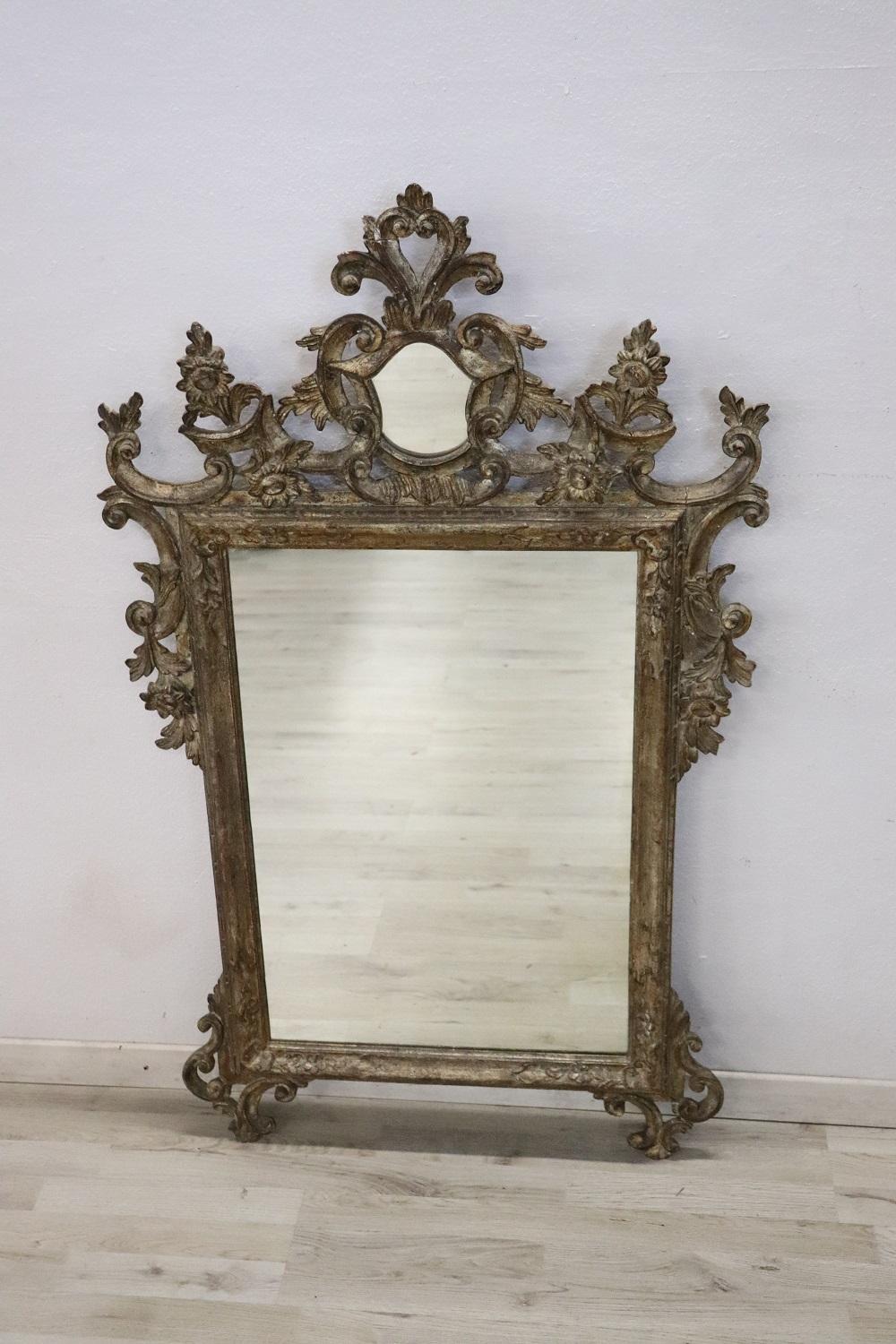 Beautiful elegant wall mirror in perfect italian Louis XV style, 1910s. Hand carved wood with finely and richly swirls and curls. Silvered wood. In good antique conditions.