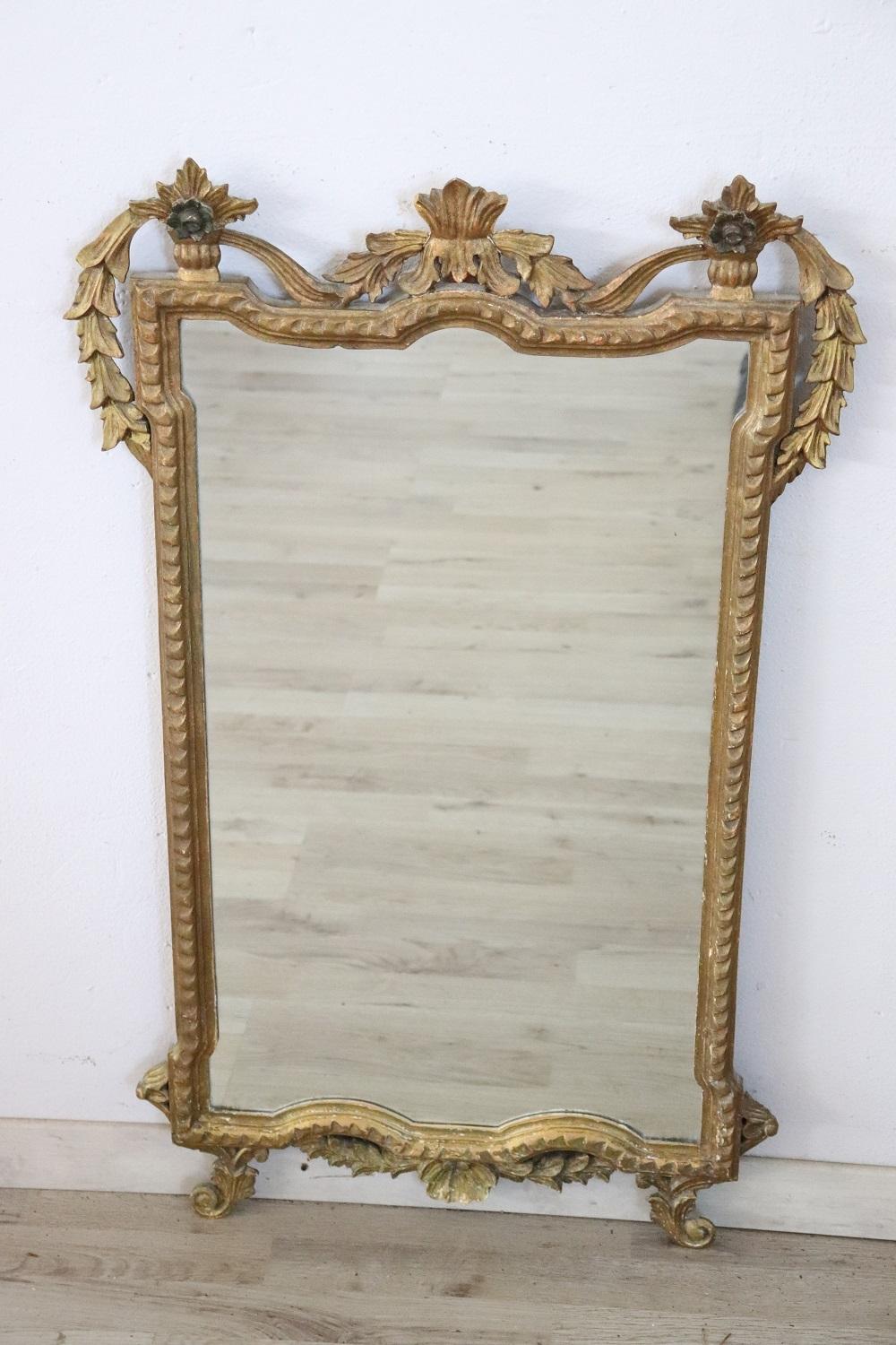 Beautiful elegant wall mirror in perfect italian Louis XVI style, 1910s. Hand carved wood with finely and richly swirls and curls. Gilded wood. In good antique conditions.
