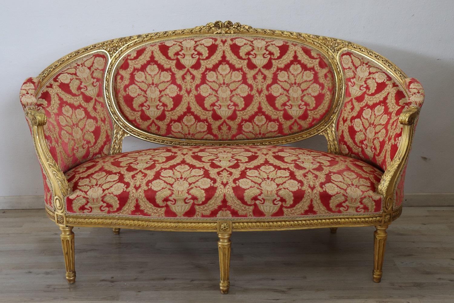Rare ensemble complet de salon de luxe italien de style Louis XVI des années 1930, comprenant :
1 grand canapé
4 fauteuils

Ensemble de salon raffiné en bois sculpté et doré. Le salon provient d'une importante villa italienne et embellit la