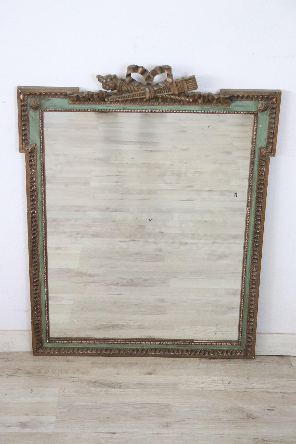 Beautiful elegant wall mirror in perfect italian Louis XVI style, 1910s. Green lacquered wood with golden decorative elements. Mercury mirror with small defects. In good antique conditions.