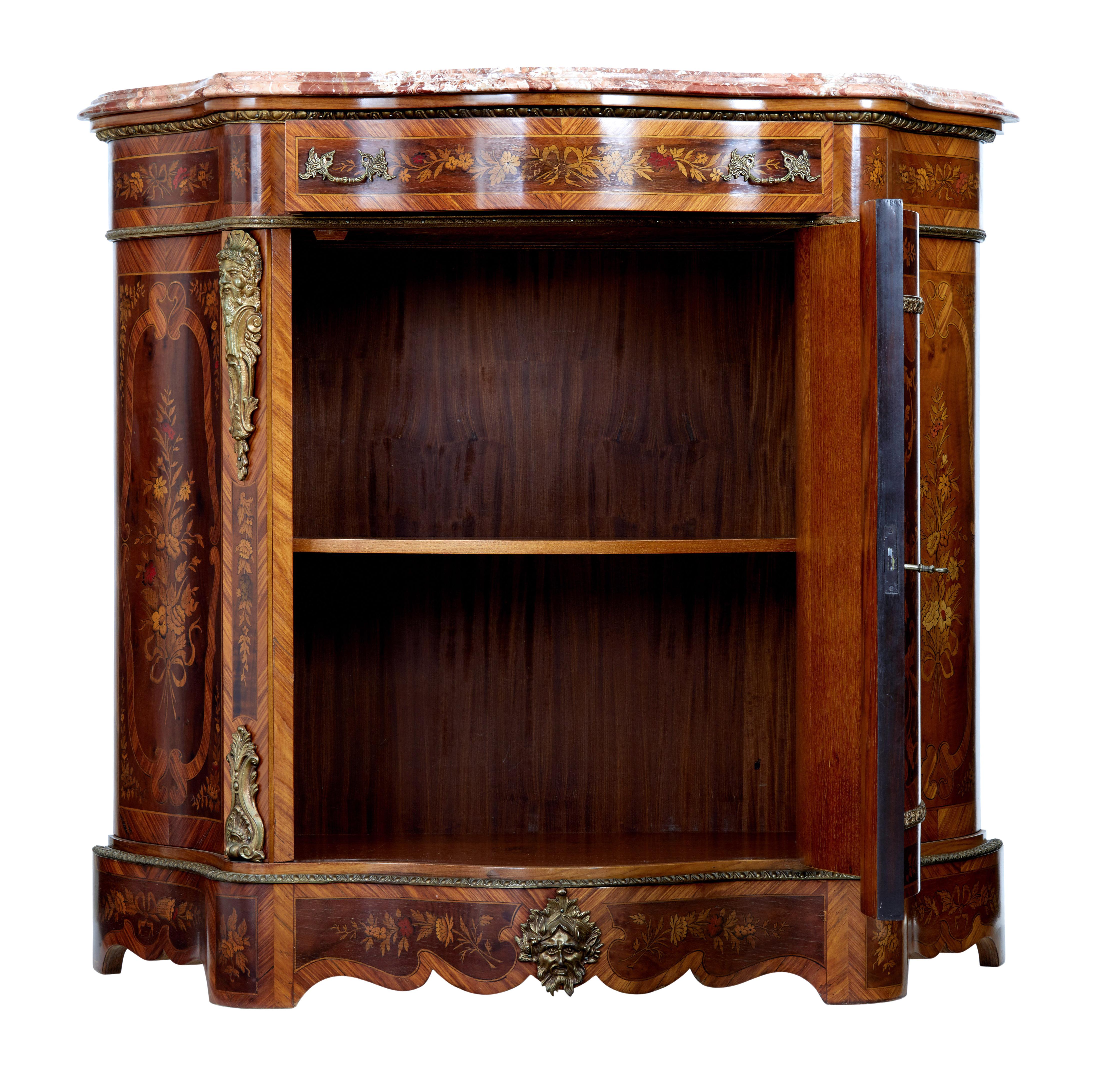 Fine quality marble top sideboard circa 1900.

Serpentine shaped and profusely decorated with marquetry and inlay.

Original marble top which is loose fitted to the top. Single drawer below the top surface, below which is a single door cupboard