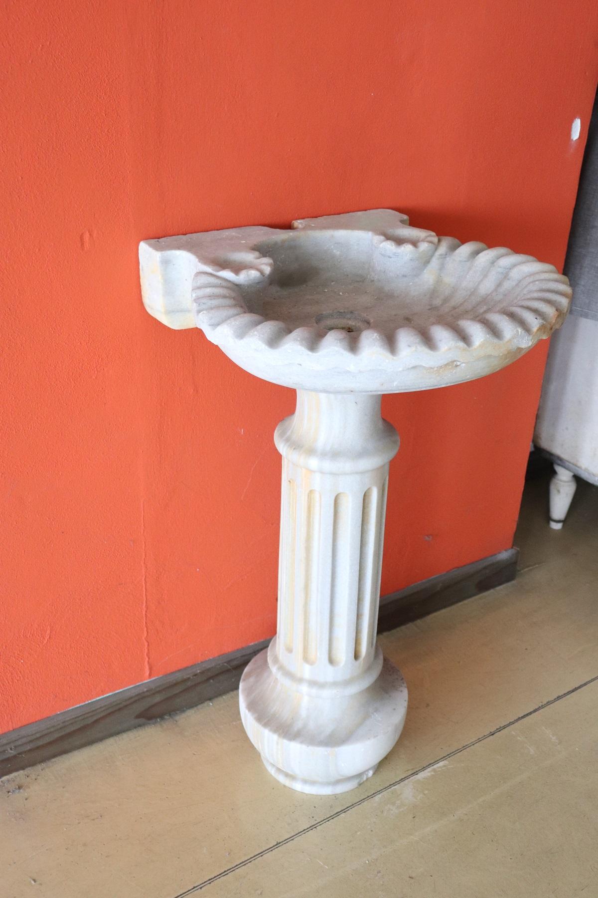 Beautiful antique Italian marble sink with fluted column and shell-shaped sink. The sink is perfect for being placed in a garden or at home. The marble has patina and signs of wear and tear and was used to embellish the garden of a large Art Nouveau
