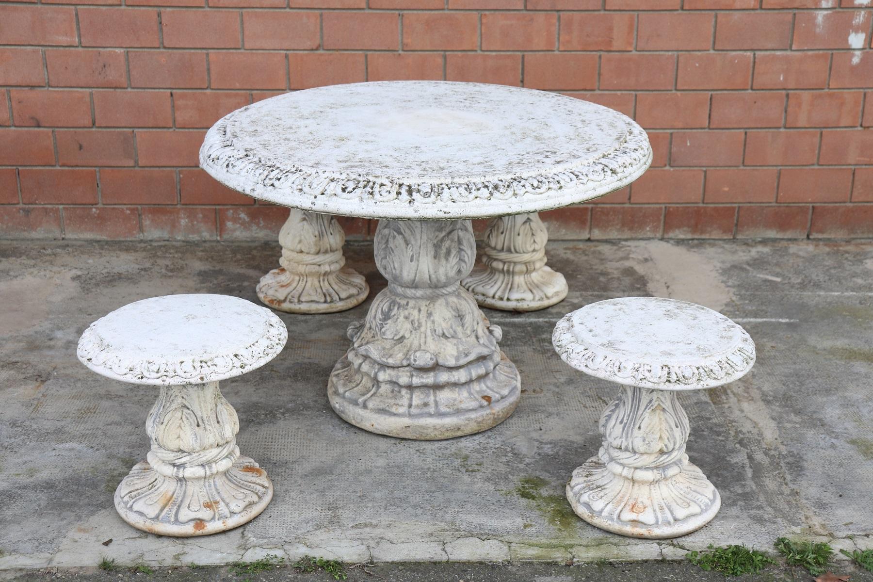 Beautiful refined garden set in neoclassical style, circa 1930s main material stone mixed with gravel and cement. Beautiful round table with bench and two stools. Gorgeous carved decoration. The stone shows signs of the passage of time. This garden
