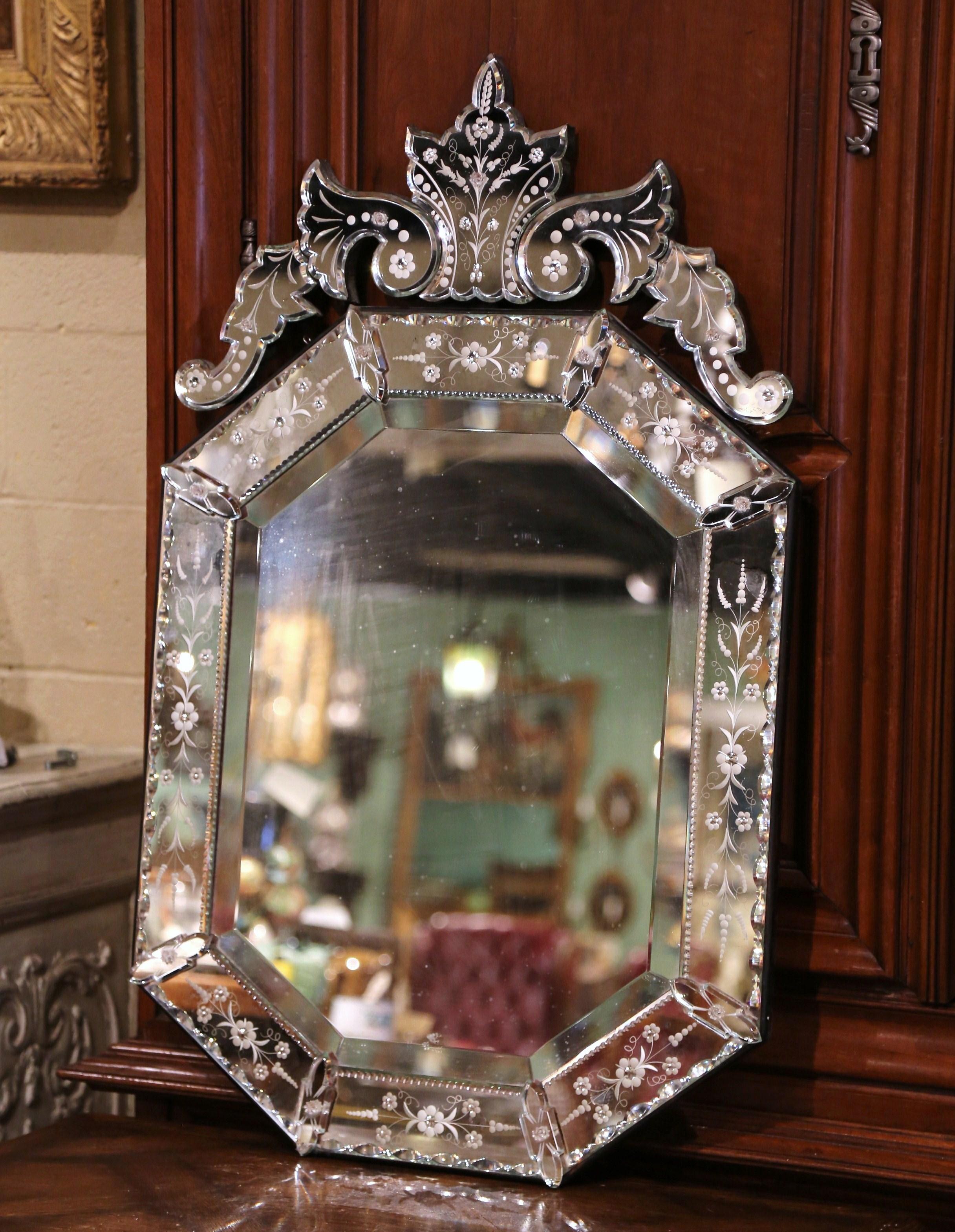 The overlay antique Venetian mirror was crafted in Italy, circa 1900, octagonal in shape, the wall piece features a large carved leaf motif at the pediment, flanked by foliage on both sides. Around the periphery, each small mirror with raised
