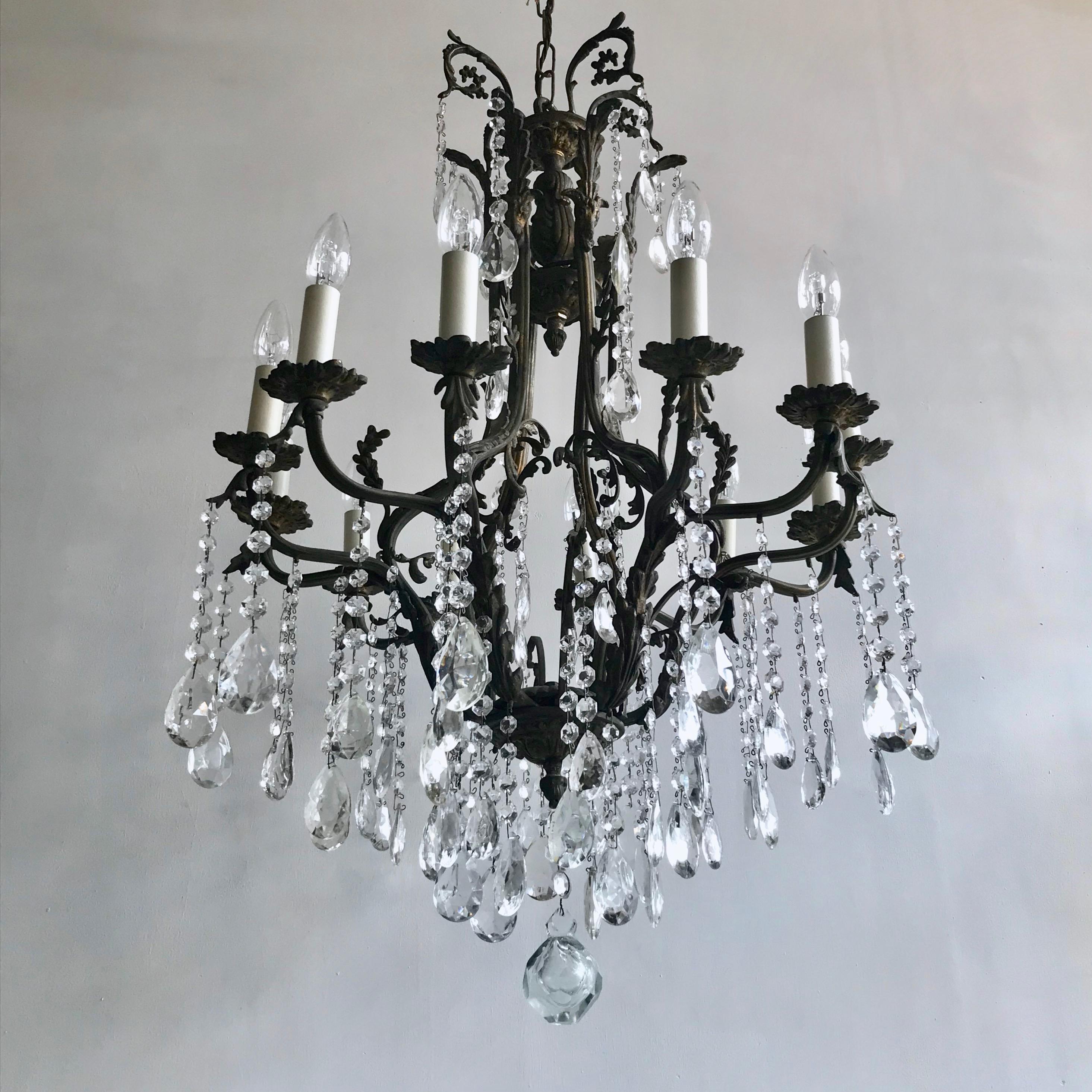 This large birdcage chandelier originates from early 1900s, Italy. Dressed in strings of glass buttons each finished with a hand cut crystal pear it is a stunning centre piece. The large chandelier frame is heavily oxidised and holds twelve lamps in