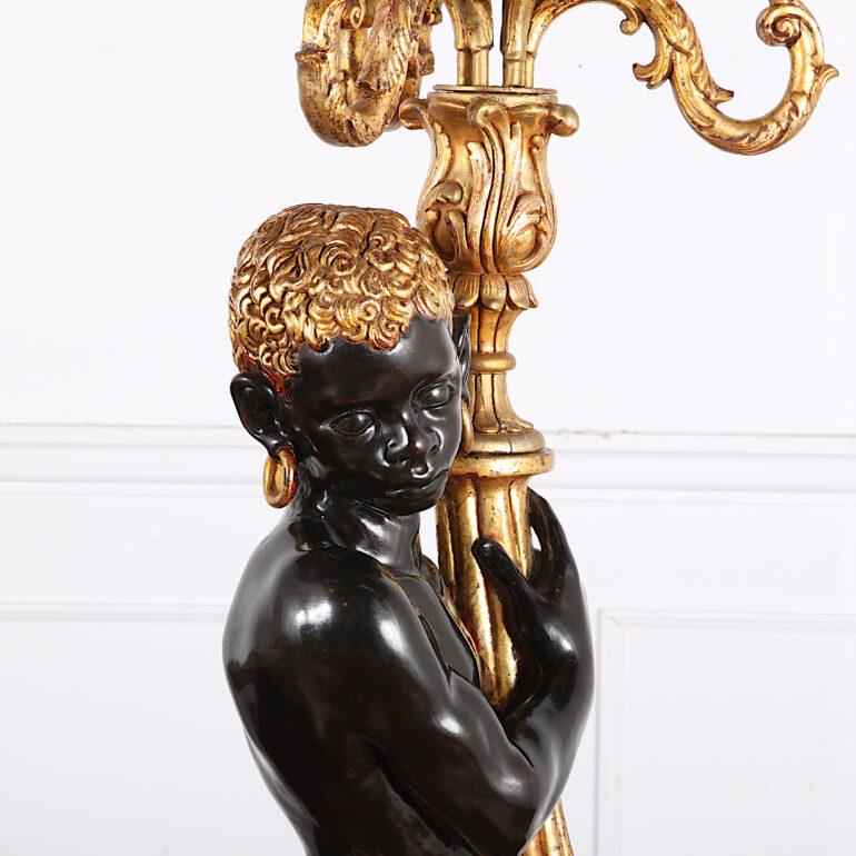 A large early-20th century Italian carved and painted figural standing ‘Blackamoor’ candelabra with finely carved and gilt details and an ornate five-branch gilt bronze torchiere light, circa 1920.

  