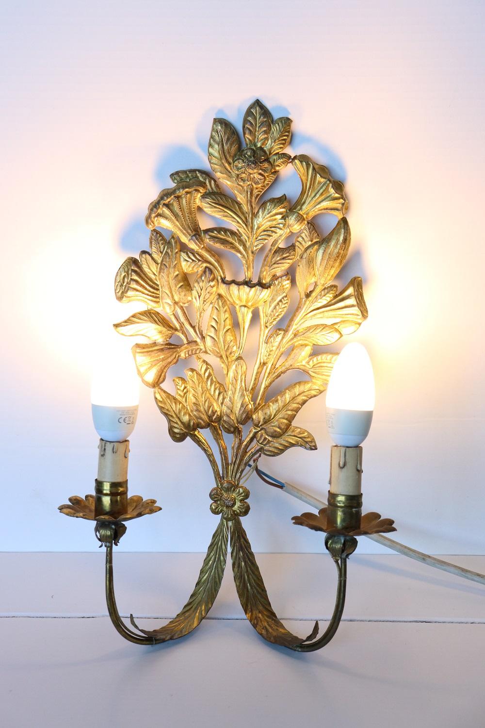 Beautiful and refined Italian early 20th century pair of wall lights or sconces two lights each. Made of gilded metal. The metal is finely chiseled with elaborate decoration with beautiful flowers. Very decorative perfect for your wall. Perfect