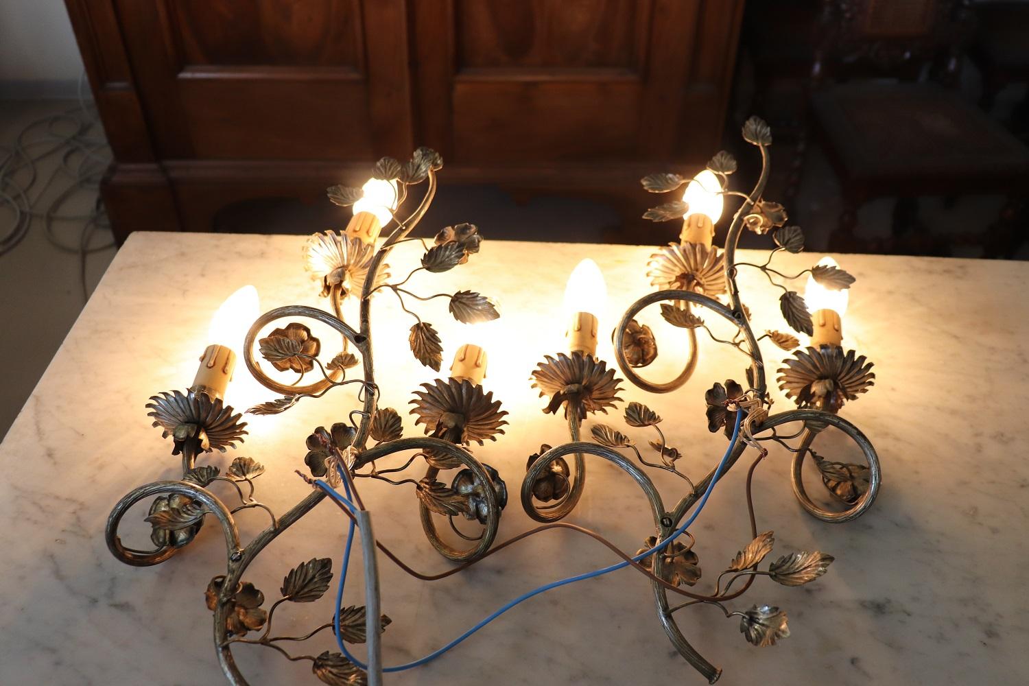 Beautiful and refined Italian early 20th century pair of wall lights or sconces three lights each. Made of silvered metal. The metal is finely chiseled with elaborate decoration. Large and beautiful flowers and roses. Very decorative perfect for
