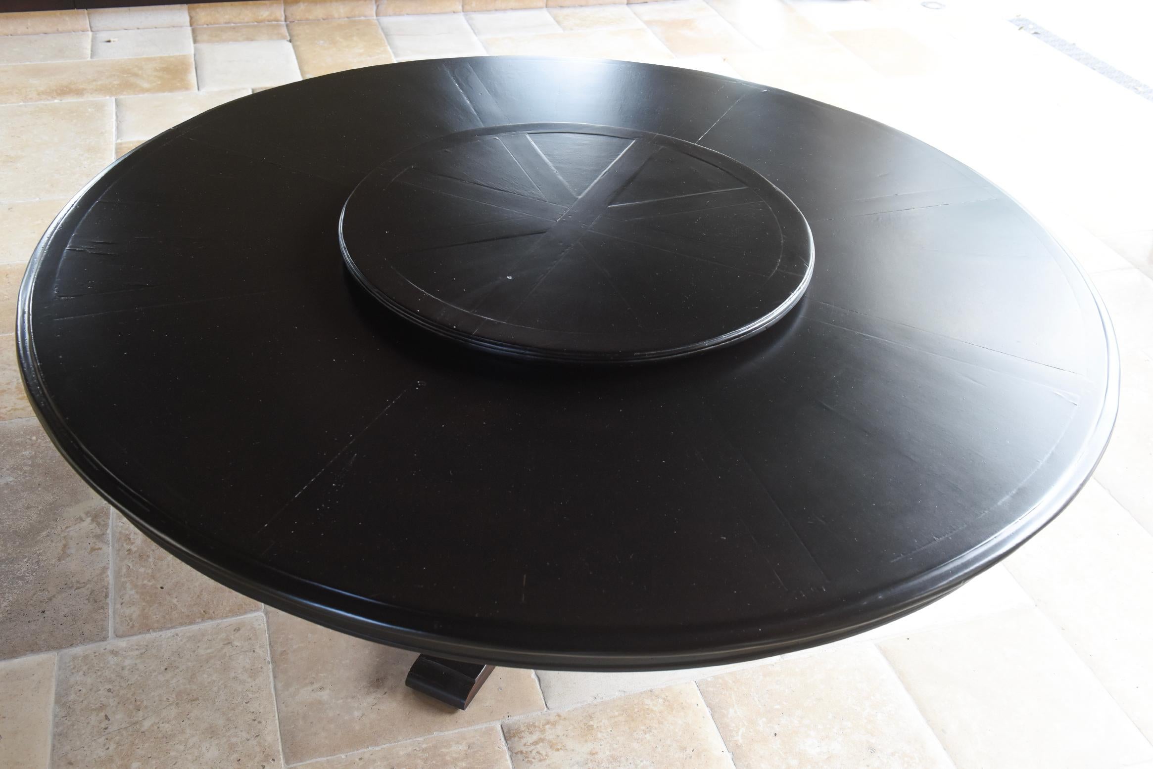 An elegant and clean-lined early 20th-century Italian round farm table crafted from solid pine. This table features a seamlessly integrated Lazy Susan at its center, enhancing functionality while maintaining a refined aesthetic. The rich dark walnut