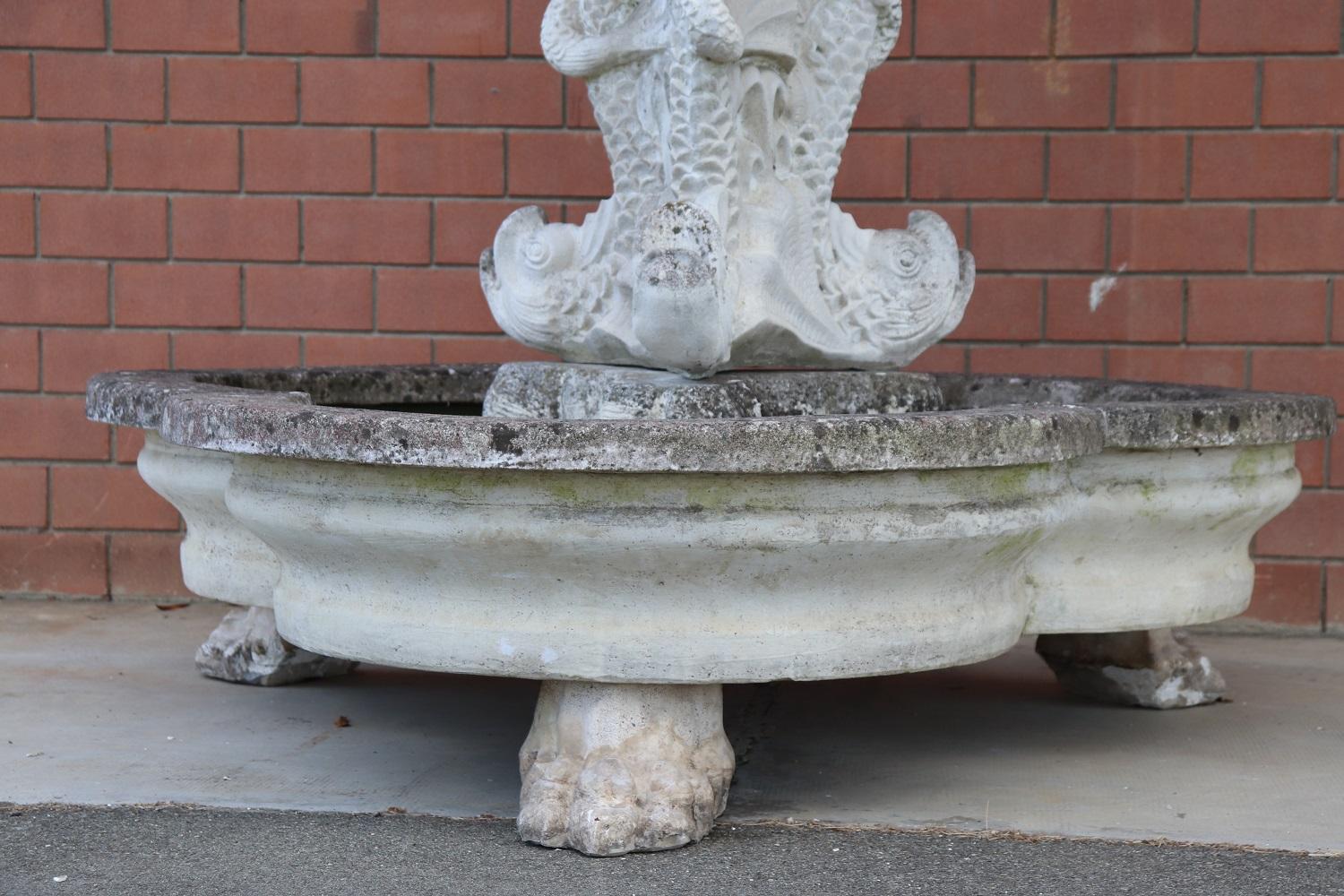 Beautiful refined garden fountain with statue in neoclassical style, circa 1930s main material mixed with grit marble dust and cement. This beautiful and majestic fountain is made up of two basins arranged on two floors. Three large fish support the