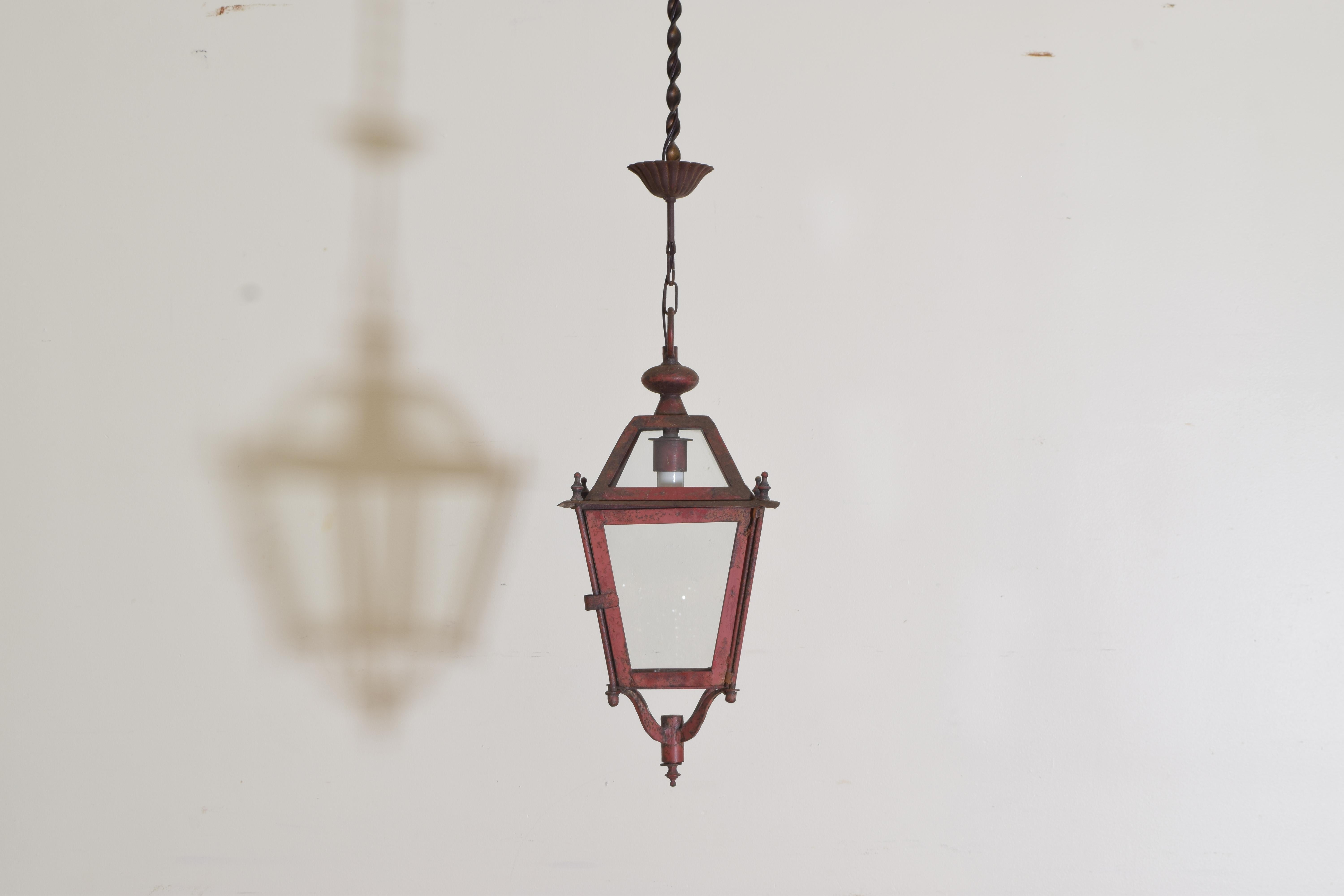 We were so excited to find this set of 11 red-painted lanterns. They are all in great aged condition retaining their original canopies which are wrought with scalloped edges. The glass roof sits over tapered lanterns having finials decorating the