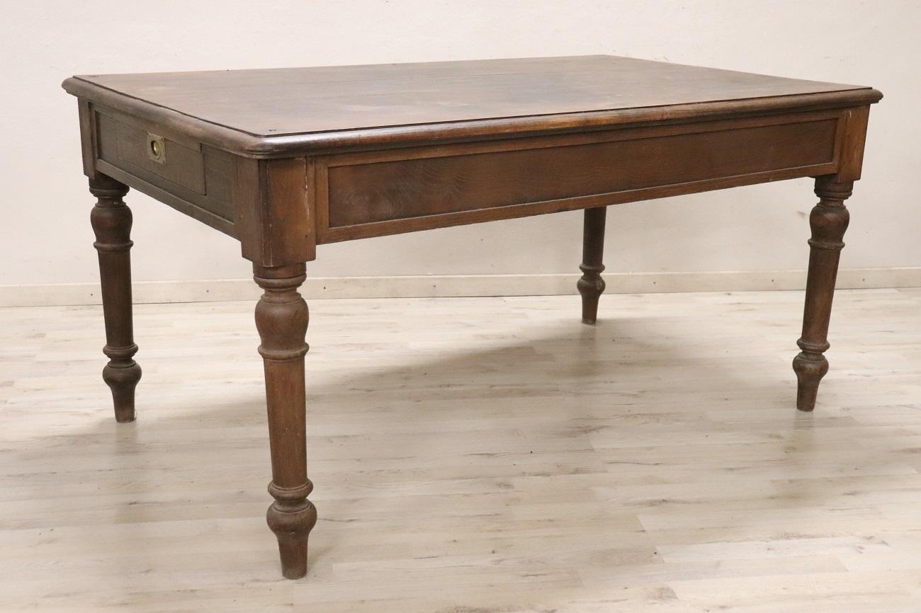 Voici cette grande table rustique italienne, fabriquée au début du 20e siècle en chêne massif. Son design simple et linéaire comporte deux tiroirs utiles sur les petits côtés, ajoutant à la fois fonctionnalité et charme. Le grand plateau offre