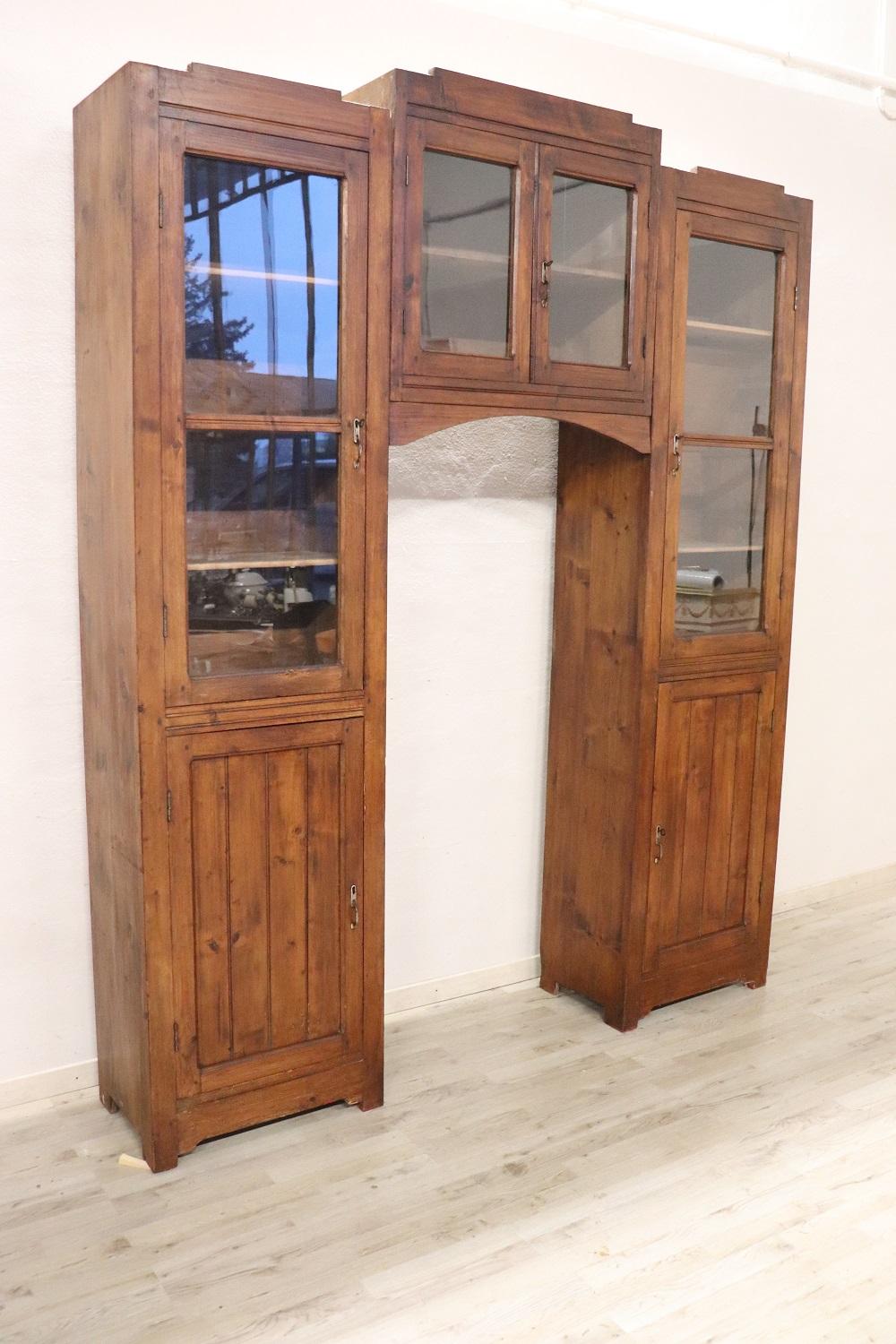 Grande bibliothèque italienne cintrée des années 1920 en bois de sapin massif. Grand espace intérieur utile. Belle ligne linéaire et rustique. Dans la partie supérieure, des portes vitrées pour exposer vos meilleurs objets ou livres. Il est divisé