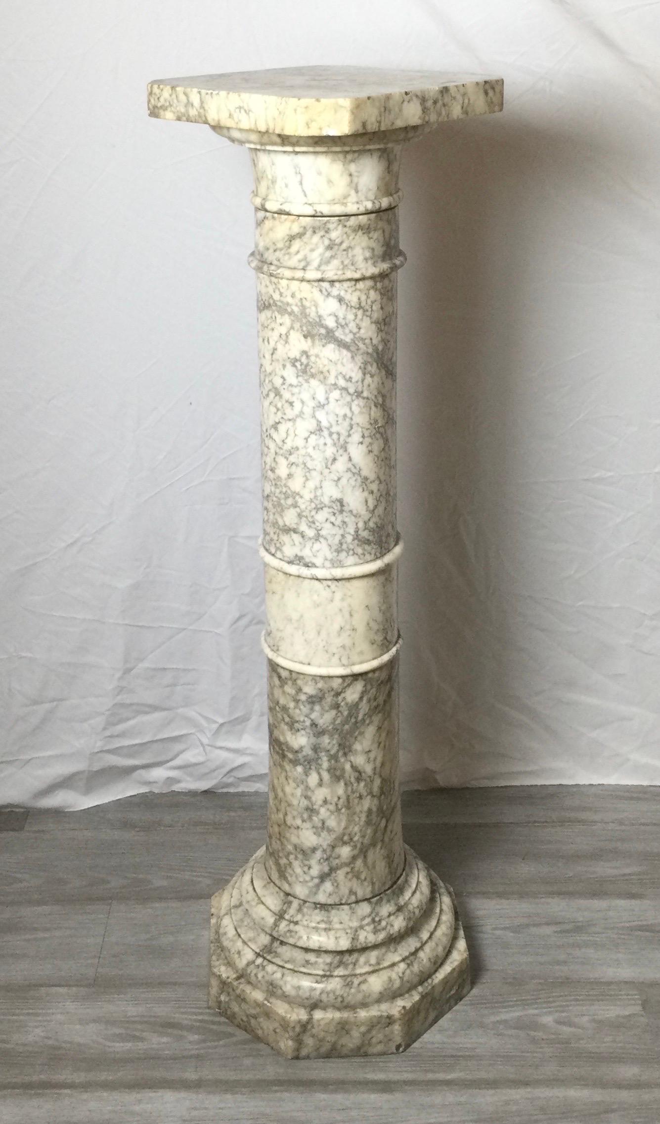 Massiver italienischer Marmorsockel aus dem frühen 20. Jahrhundert. Die Säulenform mit quadratischem Aufsatz, der gedreht werden kann, um eine Skulptur von jeder Seite zu betrachten. Der weiße Marmor mit schwarzer und grauer Maserung. Leichte