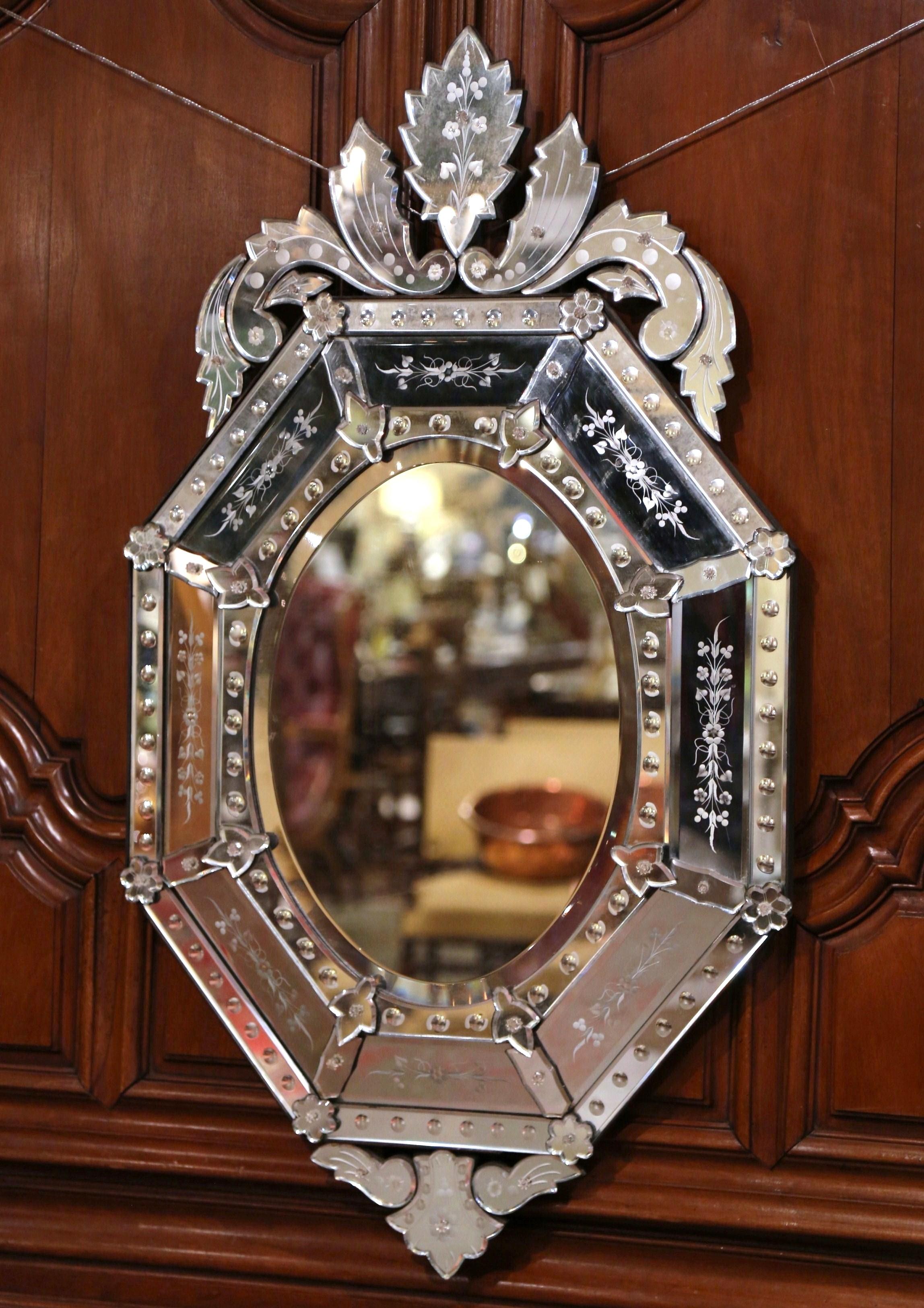 The overlay Venetian mirror was crafted in Italy, circa 1910, octagonal in shape, the wall piece features a large carved leaf motif at the pediment, flanked by foliage on both sides. Around the periphery, each small mirror with raised medallion is