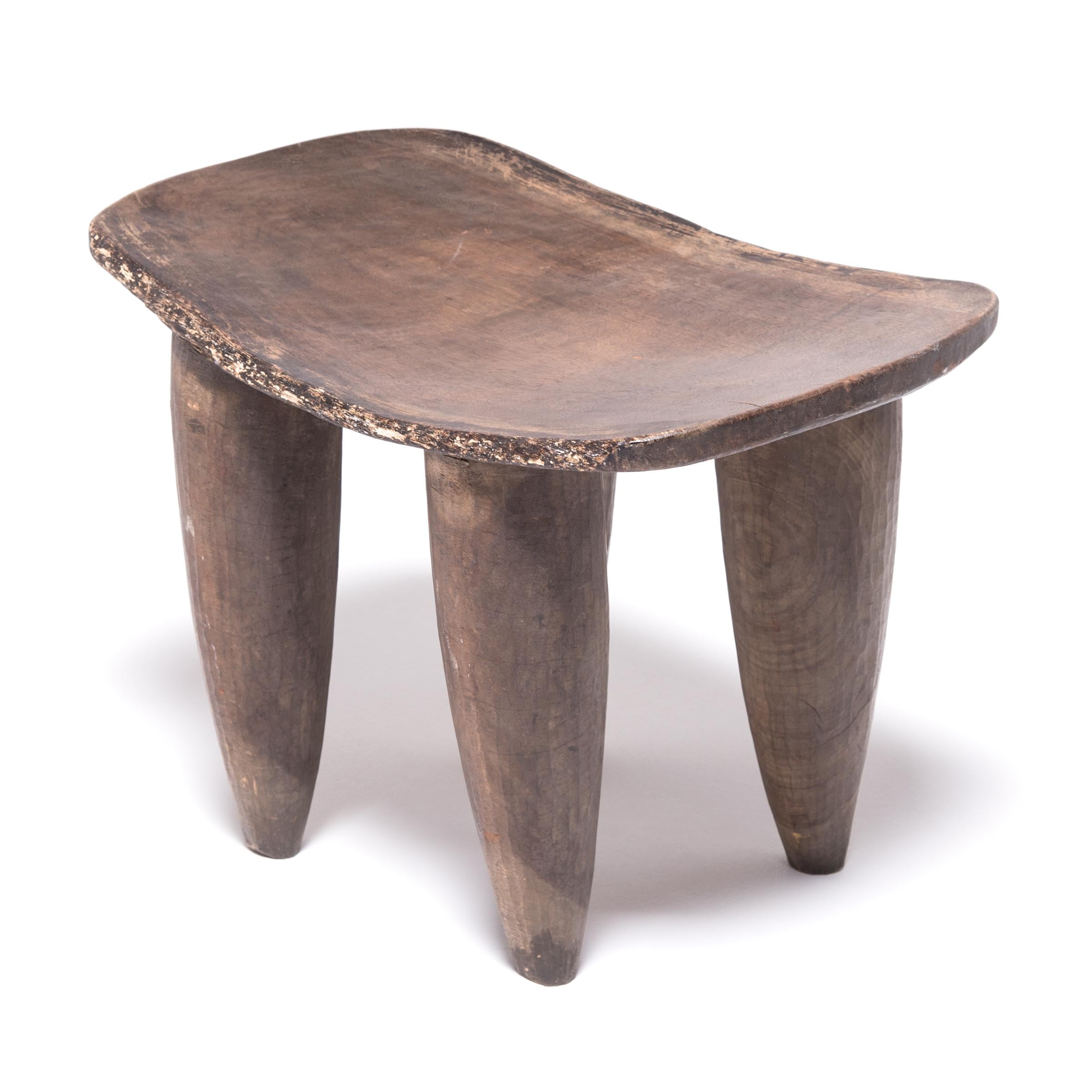 Hand-carved from a single, solid block of wood, each Senufo stool communicates a unique personality as a sculptural seat or table. The irregular carved strokes, slightly lifted seat and expressive legs are telltale identifiers. This traditional