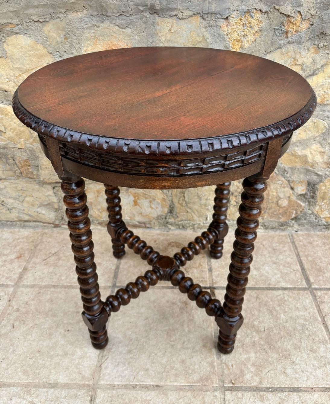 A beautifully proportioned piece featuring bobbin/barley twist turned legs, united by a cross stretcher for elegance and stability. The round top presents a rich patina with a hand-carved decorative apron and edge detailing, highlighting the