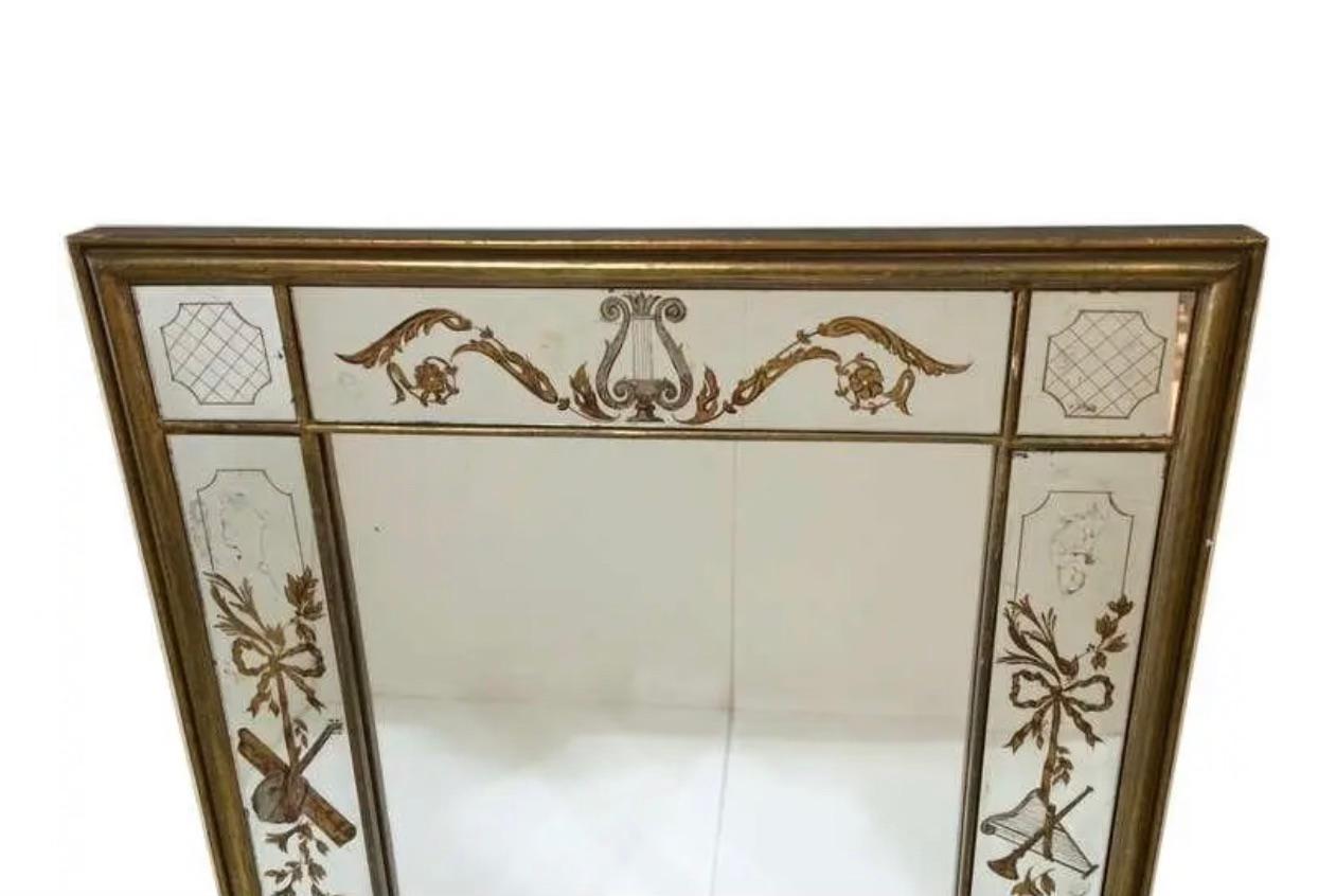 A Jansen style Eglomise mirror with instrument inspired details. 