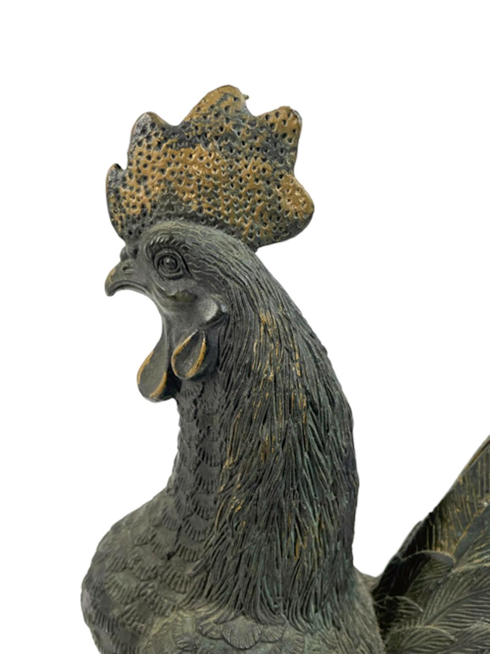 Early 20th century cast bronze figure of a rooster with good patina and traces of original gilding. Cast with nicely detailed feathers and in an alert posture. 