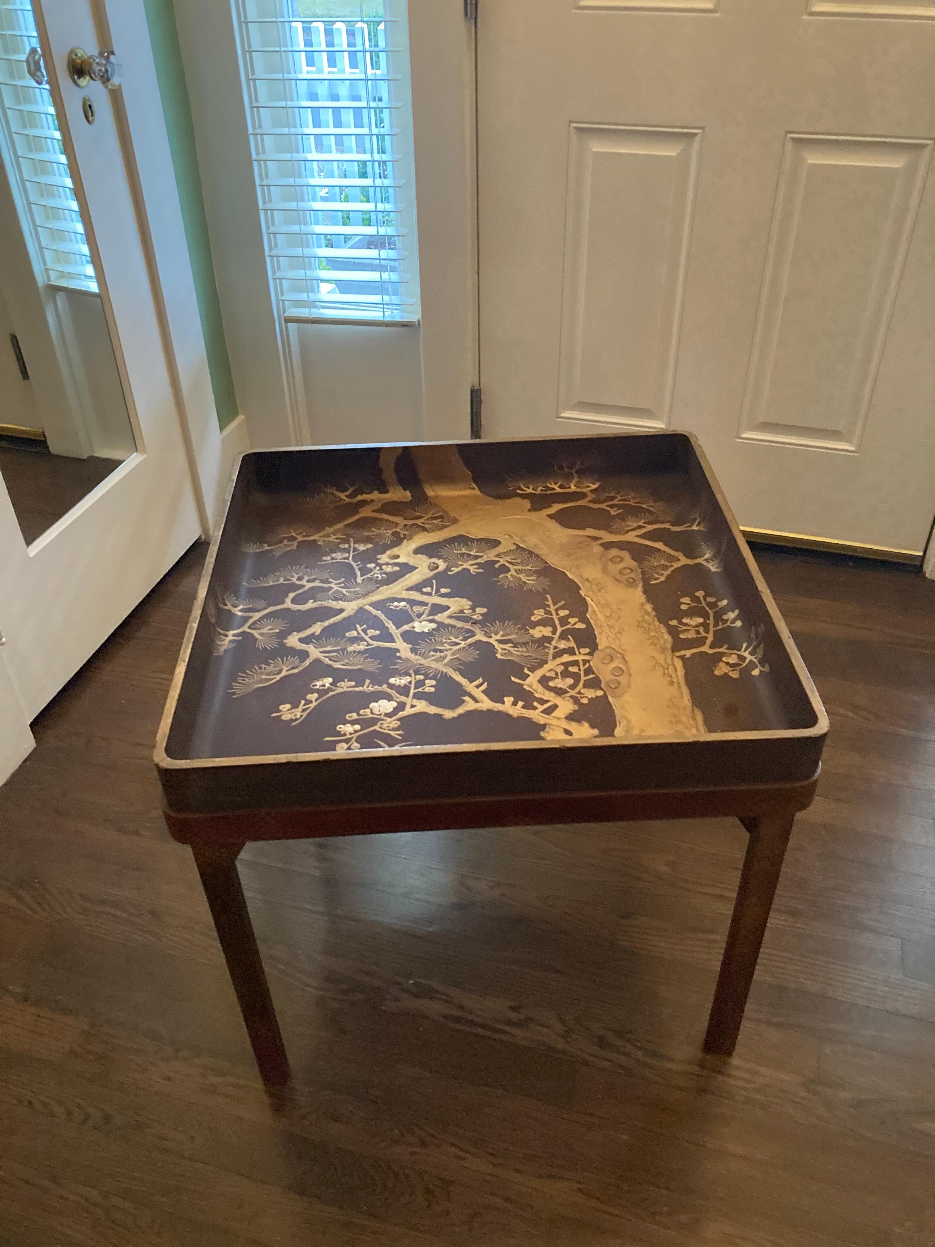 A early 20th century Japanese Lacquer tray table of a square shape sitting on a custom stand.