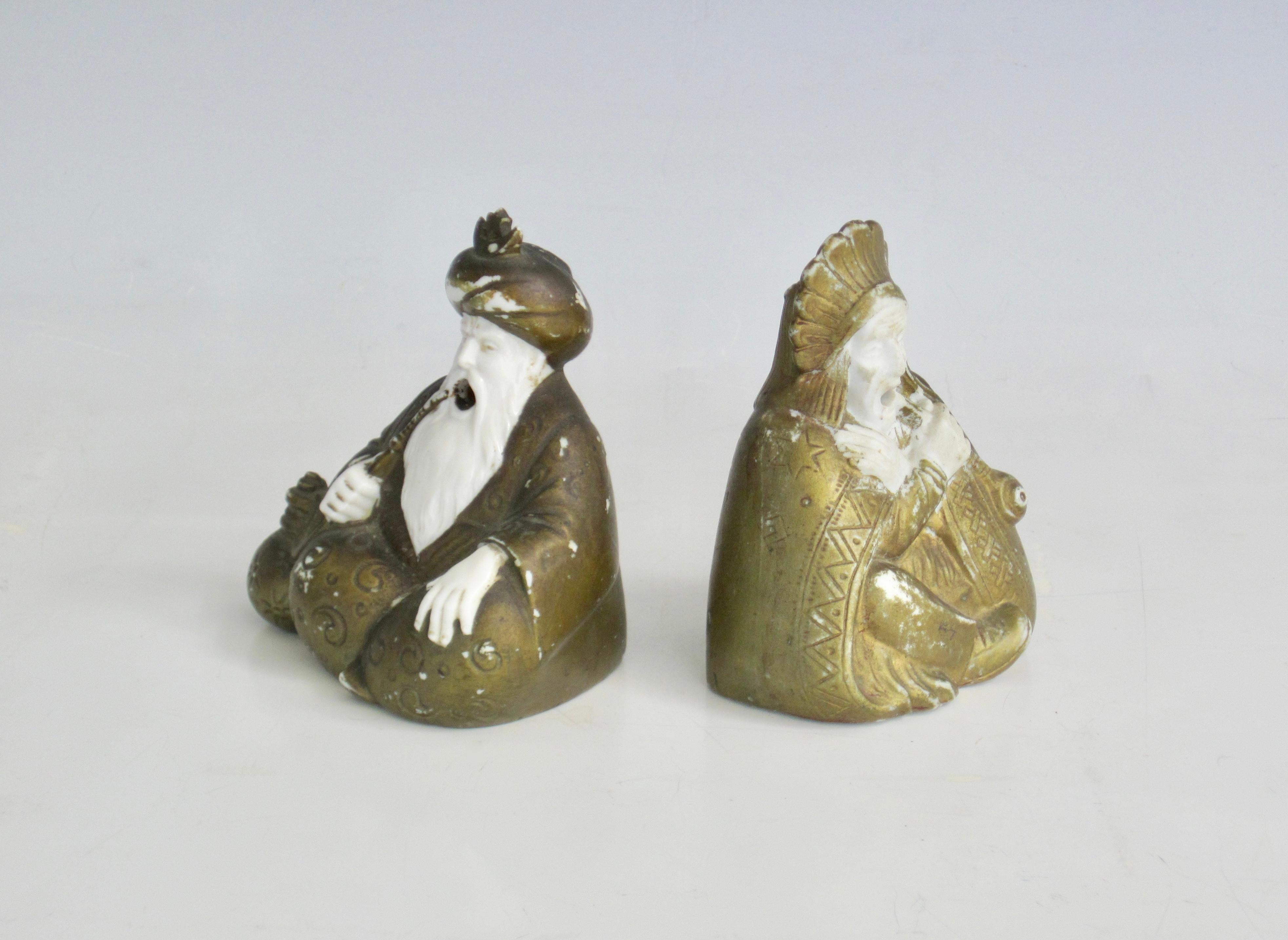 Due bruciaincenso/fumatori in porcellana giapponese dei primi del Novecento  Figurine dipinte in oro. Ognuno di loro ha un disegno sul costume che indossa. 
Il capo ha un semplice disegno indigeno e stelle incise sulla sua coperta e un copricapo di