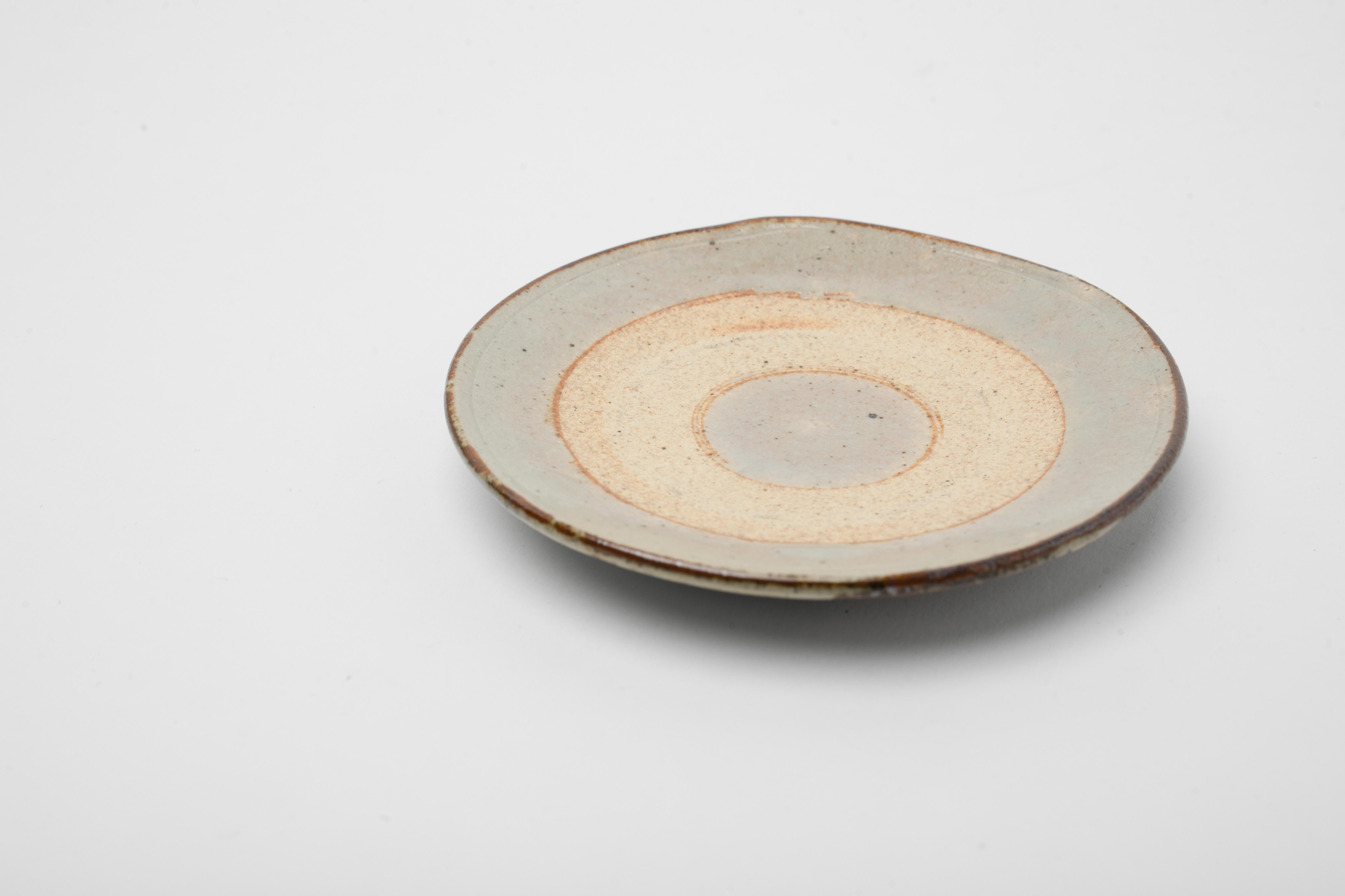 Beautifully crafted small plate from Japan. As you can see in the images only a small circle motif of the plate was left unglazed. It has a primitive feeling and old world energy. The piece is very simple and yet almost defines the wabi sabi