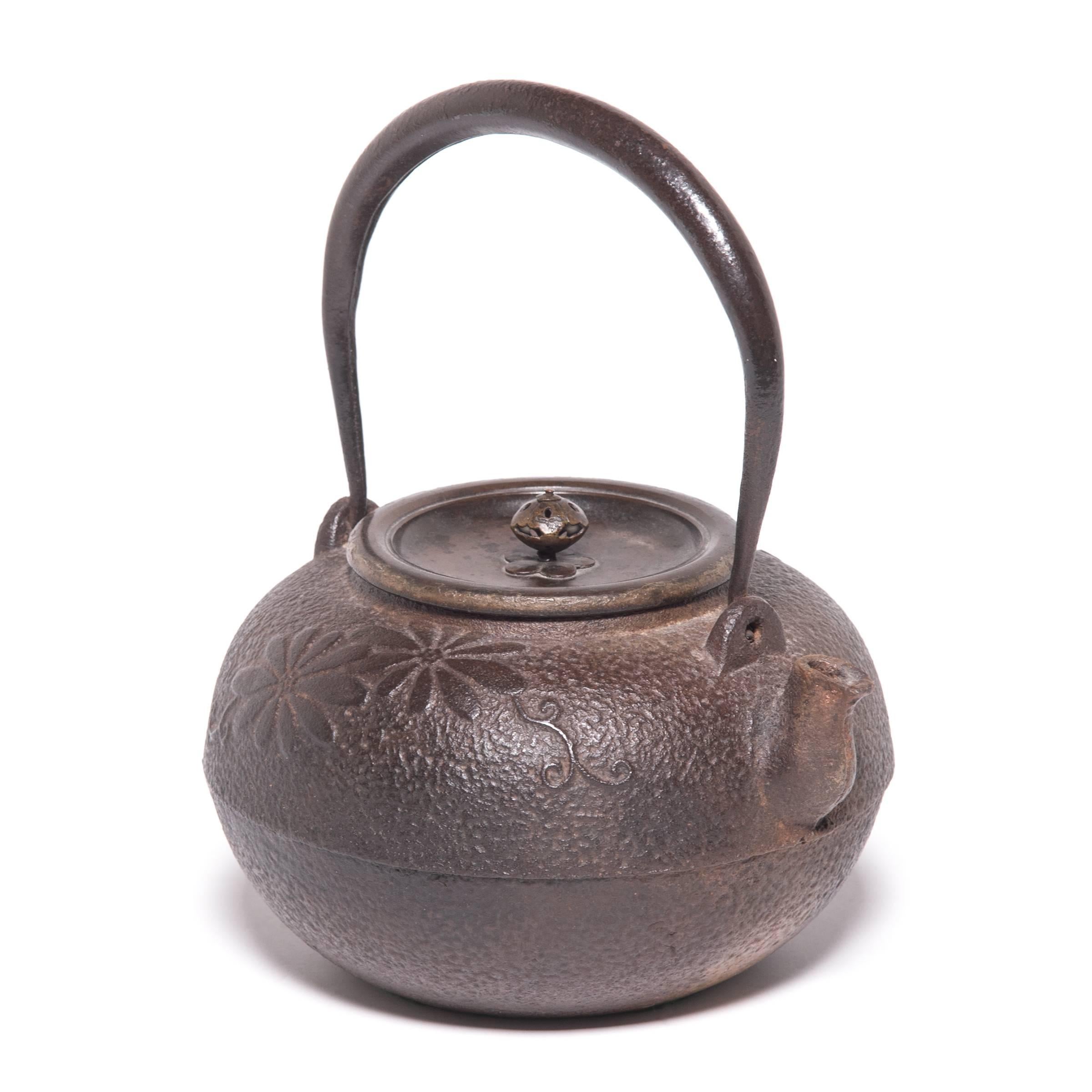 Decorated with stylized chrysanthemum blossoms, symbols of longevity and rejuvenation, this Japanese teapot was used to boil water for traditional tea ceremonies. Known as tetsubin, the kettle’s cast-iron construction is said to change the quality