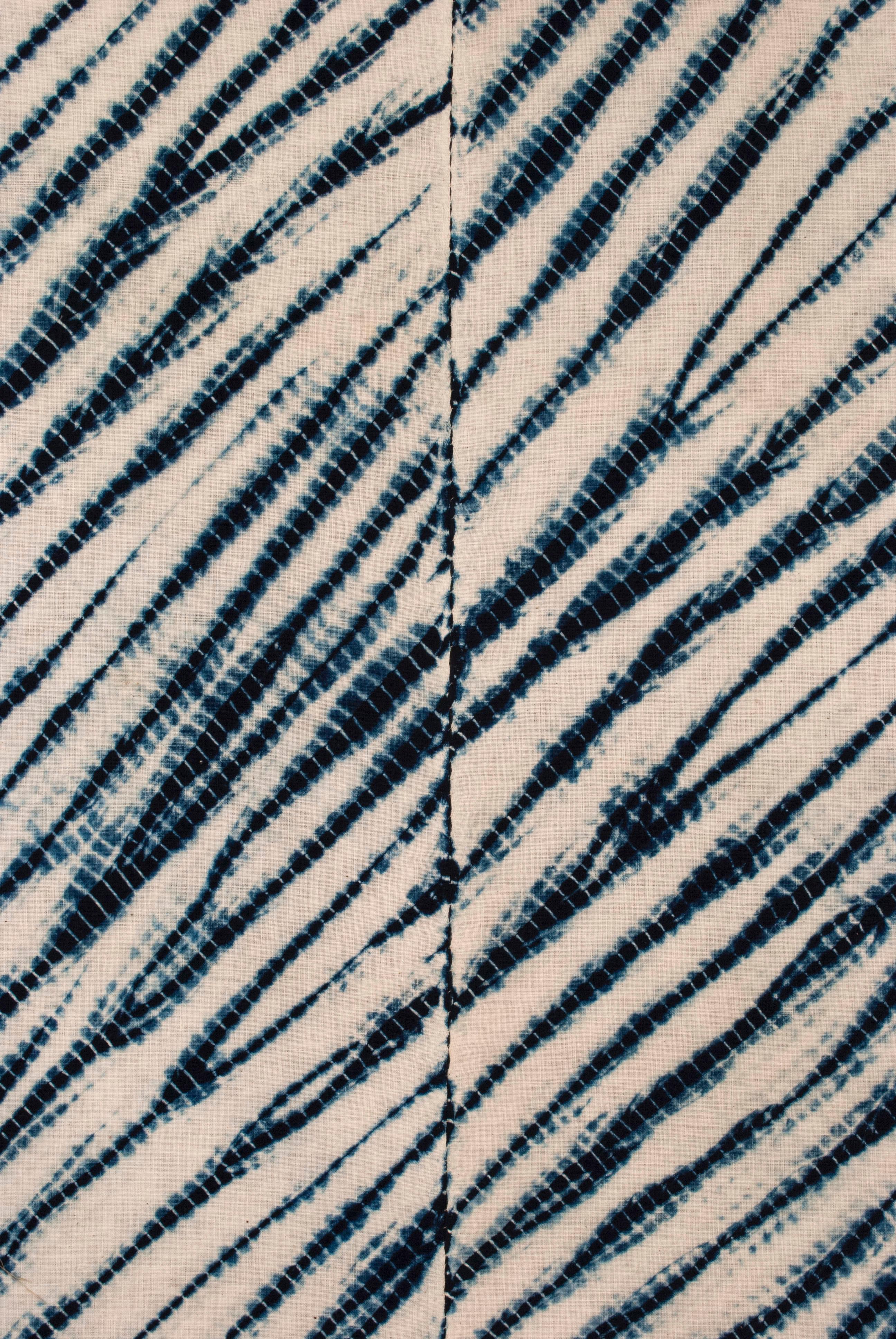 Early 20th Century Japanese two-panel shape-resist dyed textile / Arashi shibori

A graphic example of Japanese shibori. Two panels of hand-spun cotton dyed with natural indigo using the shibori technique known as ‘arashi’ shibori (pole-wrapping).