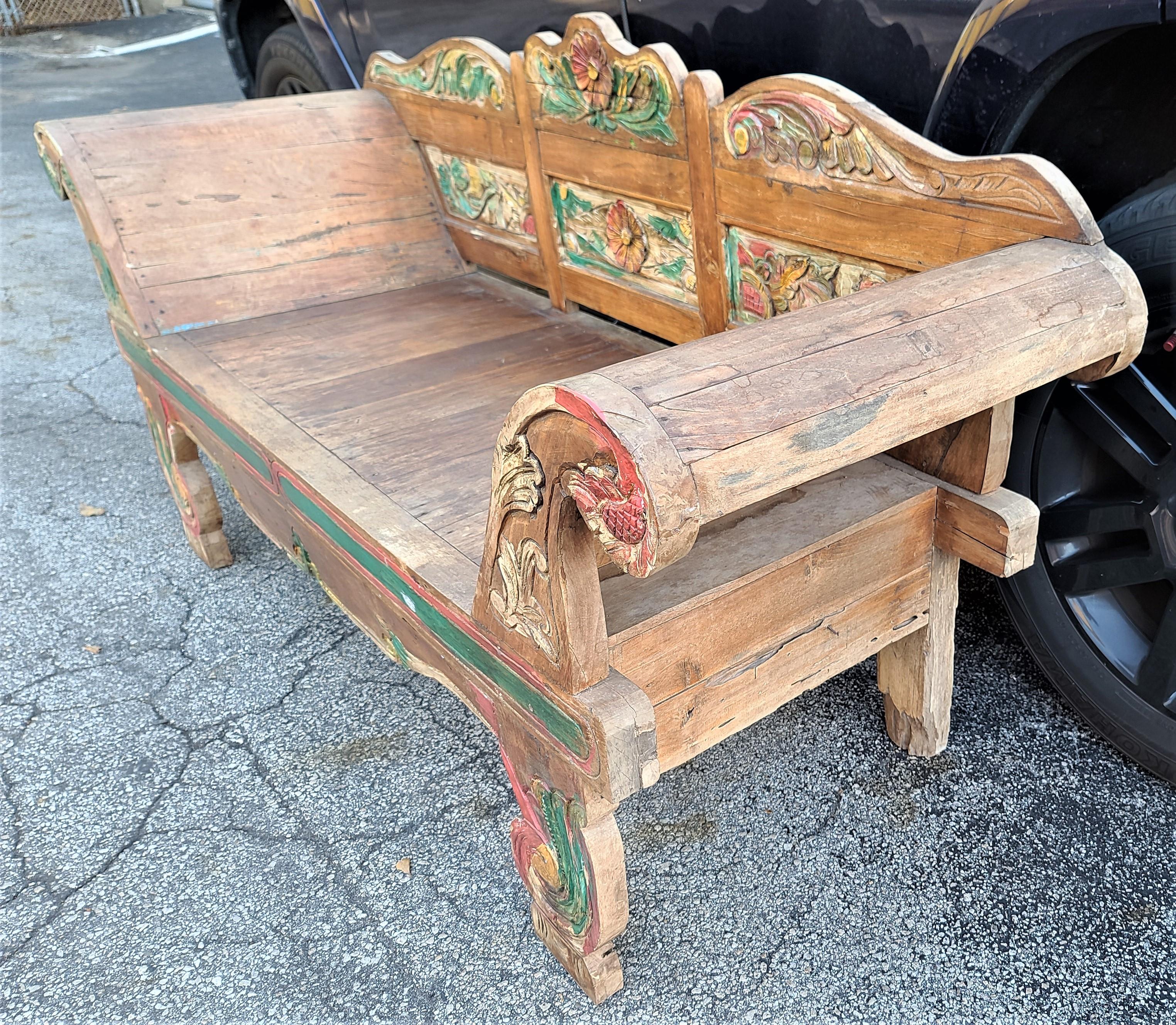 Offering One of our recent palm beach estate fine furniture acquisitions of
A Javanese teak plantation settee from the early 20th century, with hand-painted polychrome decor, carved volutes, and substantial out-scrolling arms.

Approximate