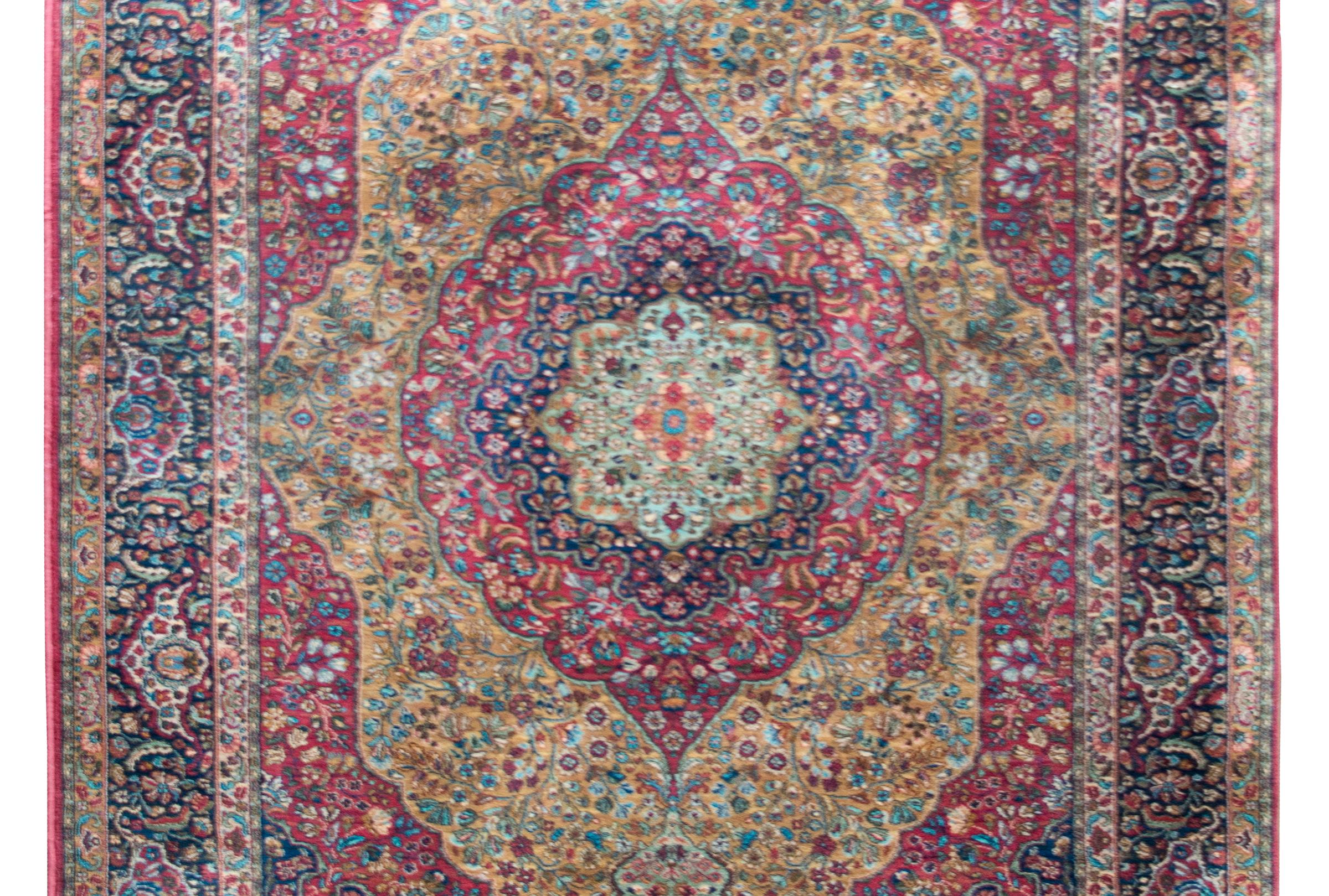 A beautiful early 20th century American Karastan-style rug with a large central floral medallion with even more floral medallions radiating out, all woven with myriad flowers and scrolling vines, and all surrounded by a complex border with several