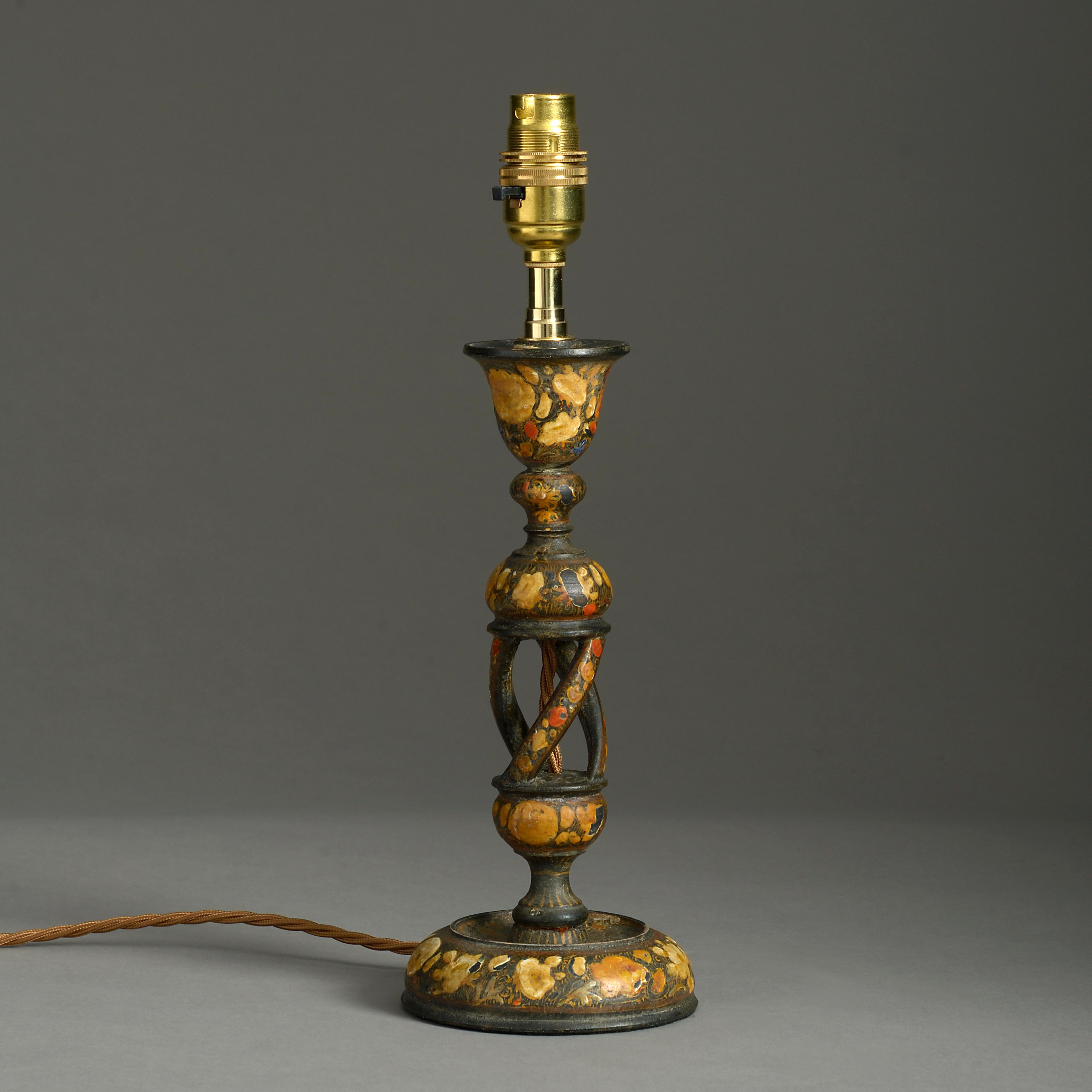 An early 20th century Kashmiri lacquer table lamp of small scale, decorated with stylized polychrome floral designs and having a twisting stem, raised upon a circular base.

Dimensions refer only to lacquered elements.

Shade available to